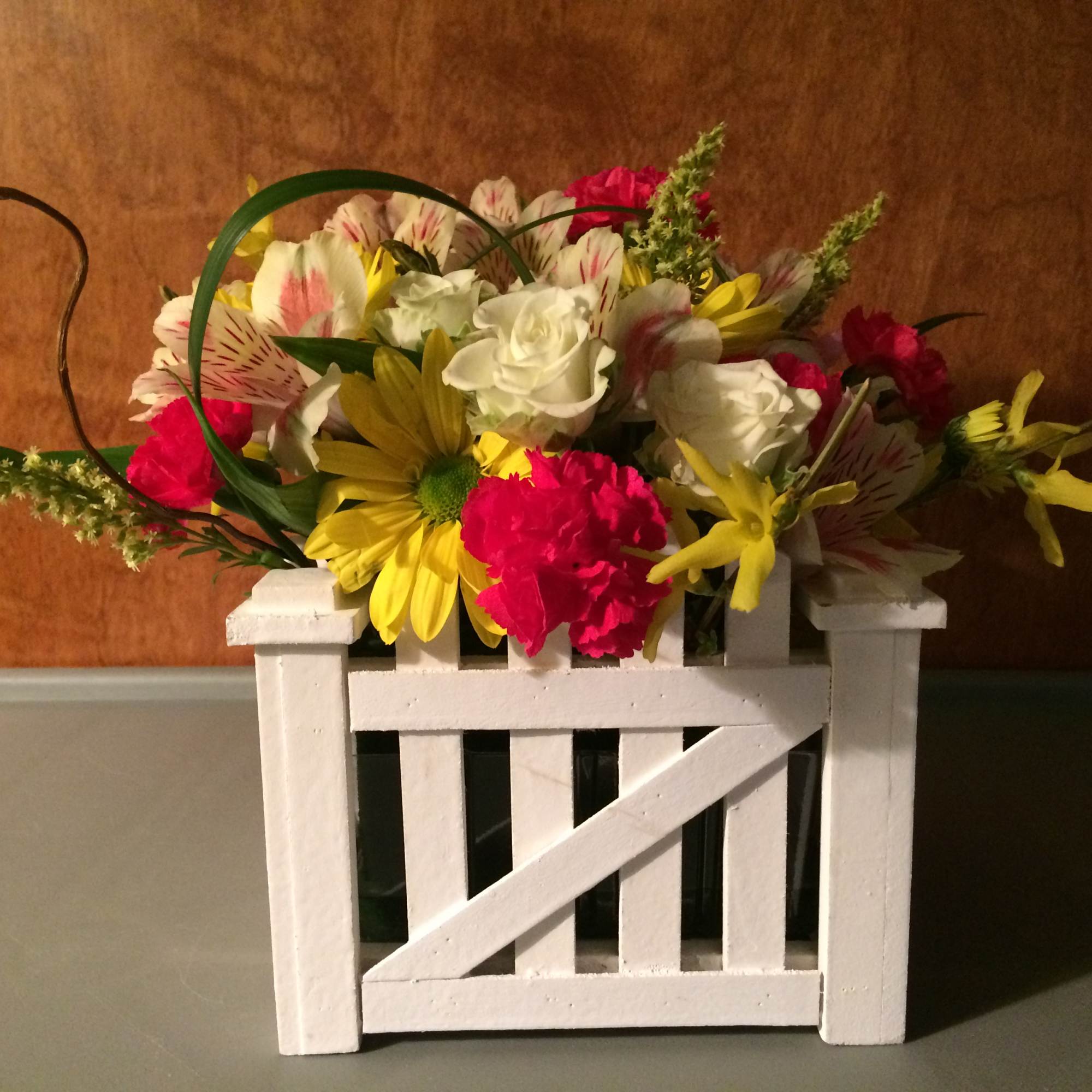With flowers appearing to be spilling over this wooden gate. We will