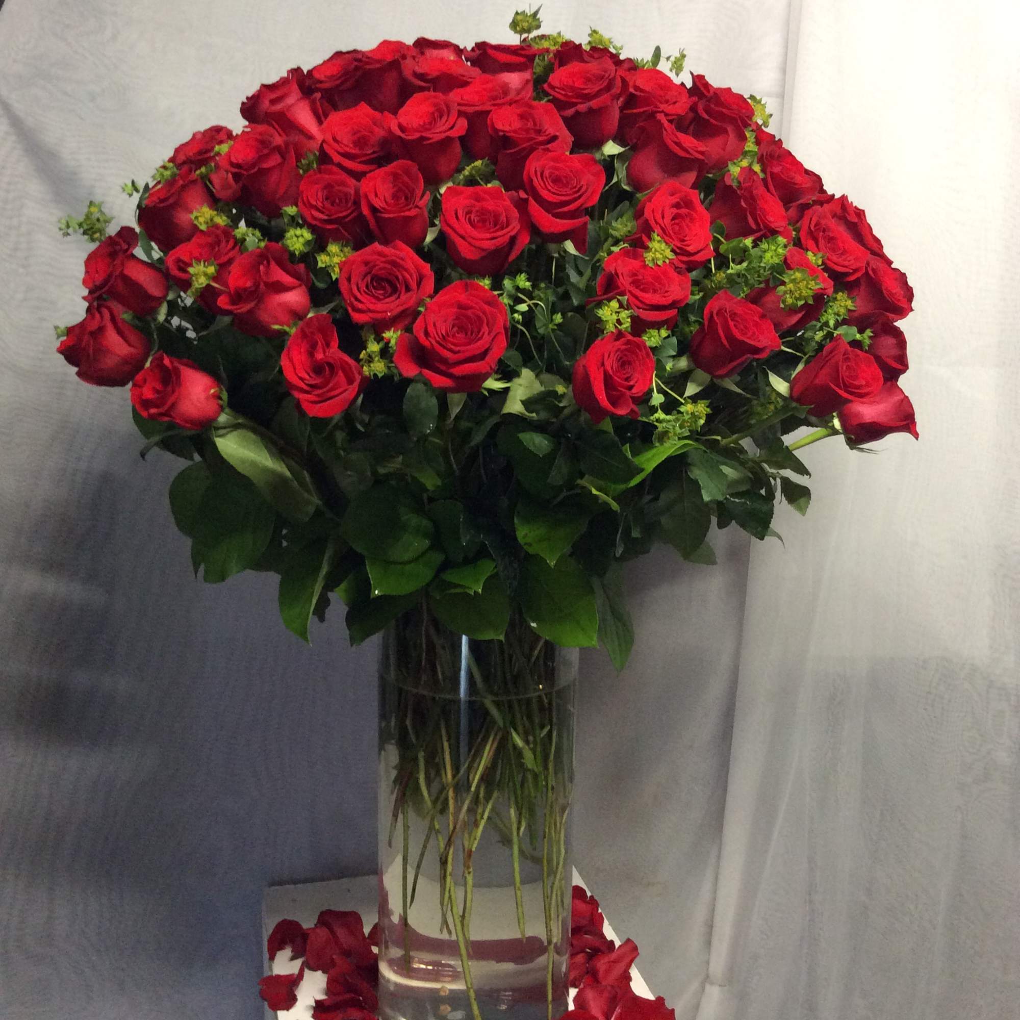 Beautiful flower arrangement with 100 red roses in cylinder vase 