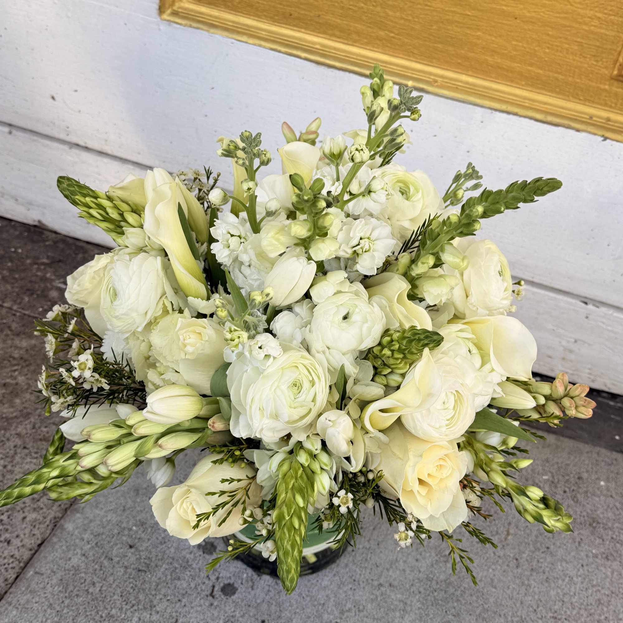 This sophisticated arrangement features a harmonious blend of creamy whites, soft ivories