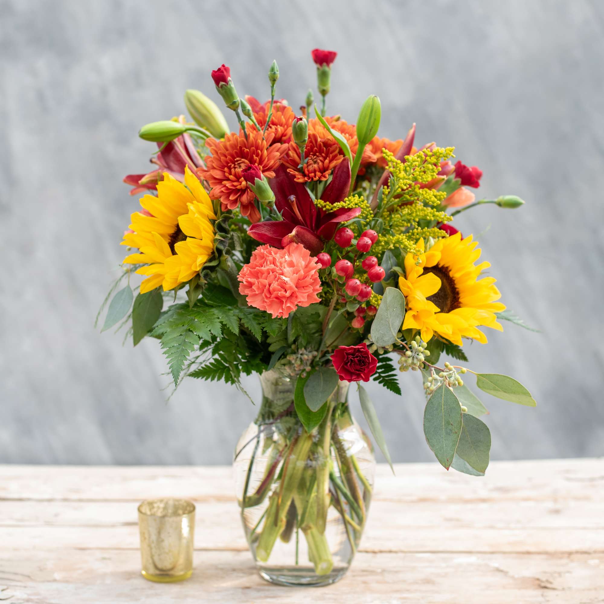 A beautiful autumnal mix including sunflowers, lilies, mums, carnations accented with hypericum A beautiful autumnal mix including sunflowers, lilies, mums, carnations accented with hypericum