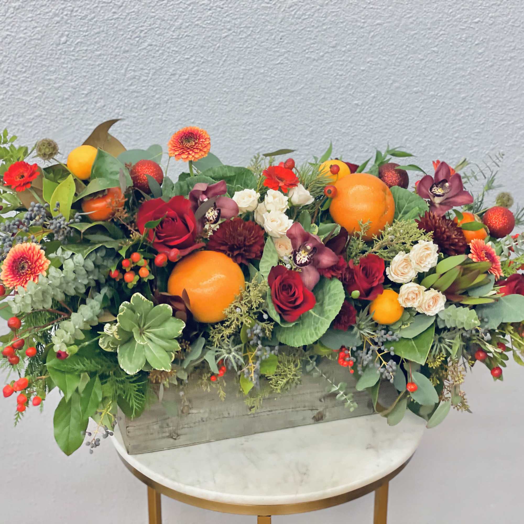 Holiday joy in a box!  Red roses, festive berries, persimmons, grapefruit