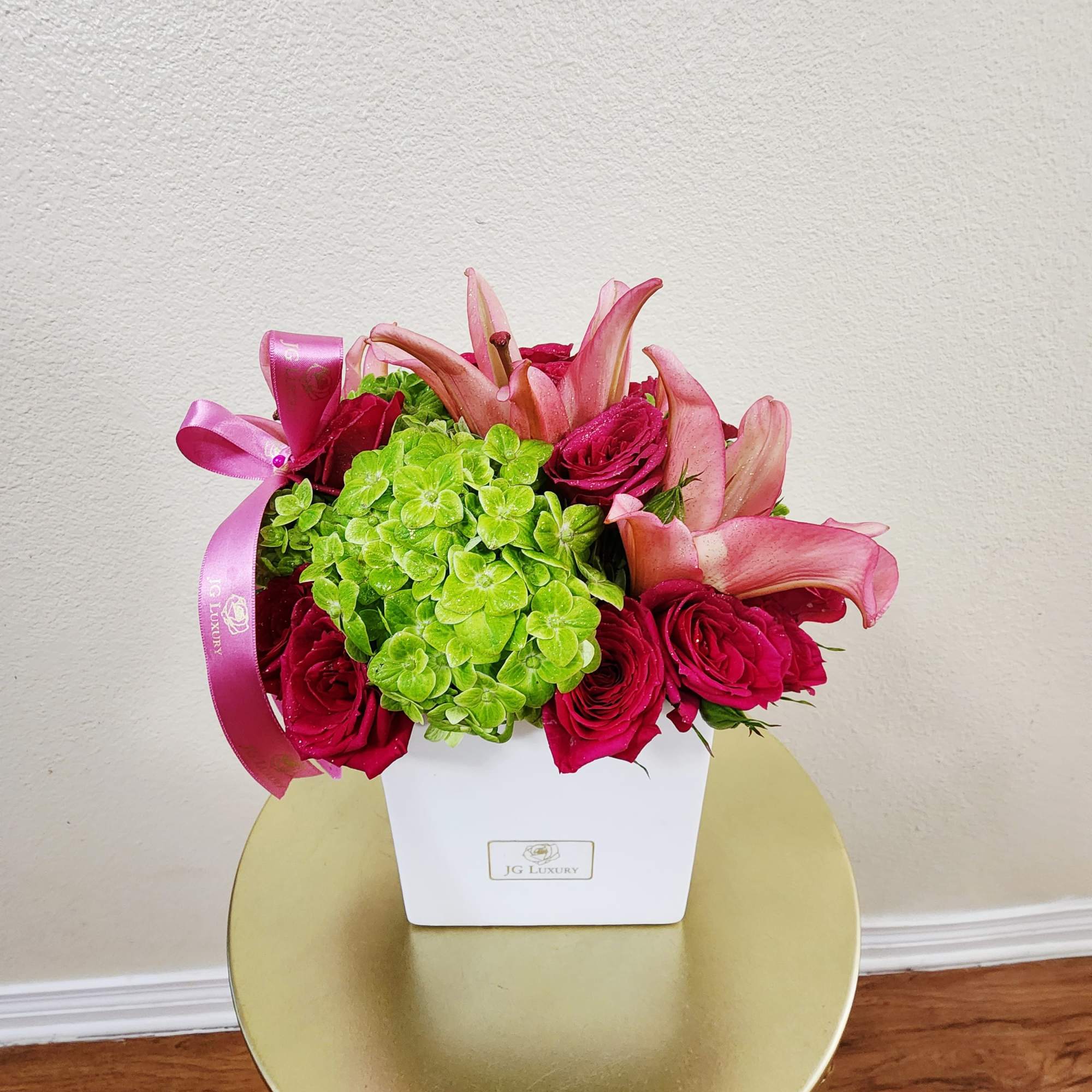This colorful, spring bouquet contains lilies, spray roses, and hydrangea. It is