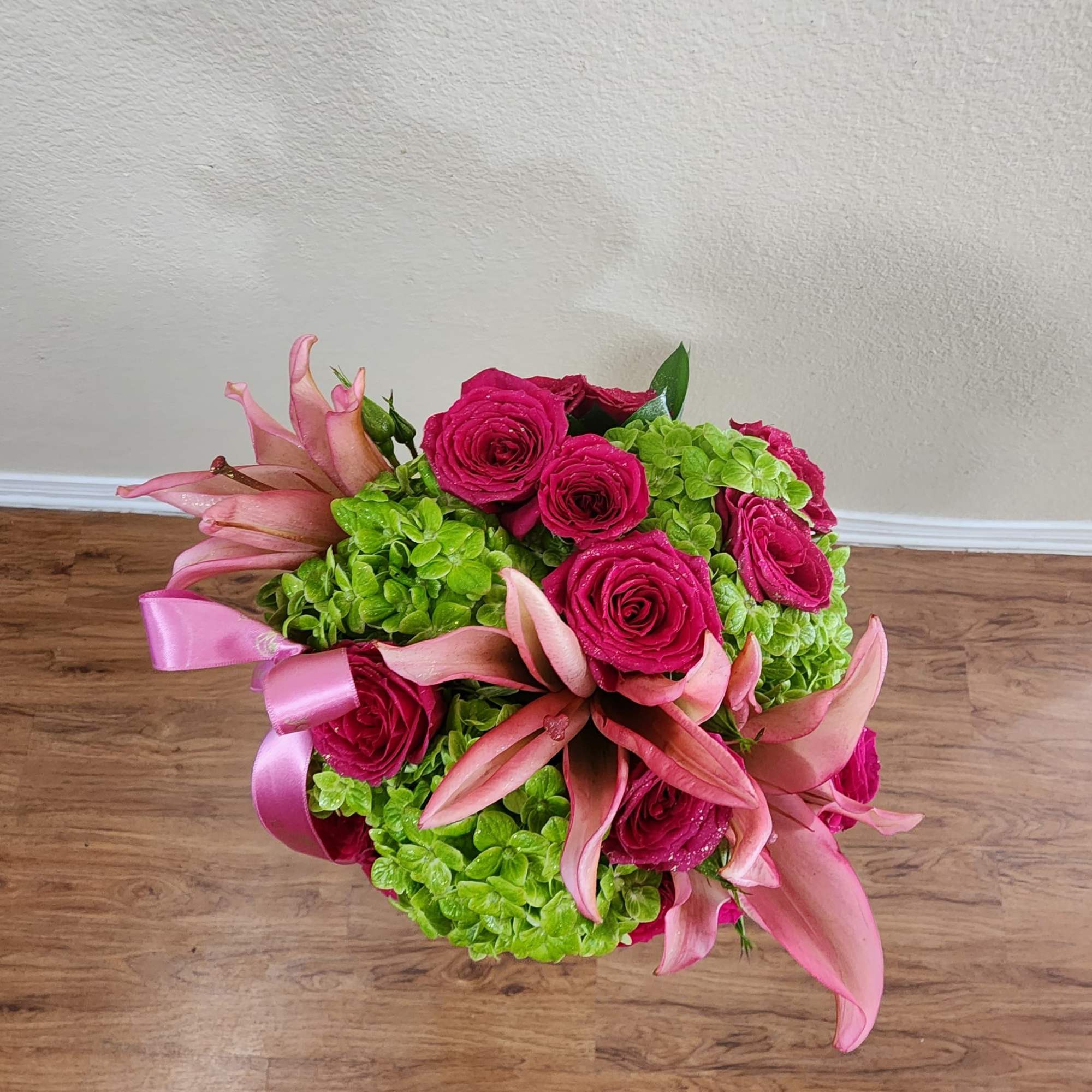 This colorful, spring bouquet contains lilies, spray roses, and hydrangea. It is