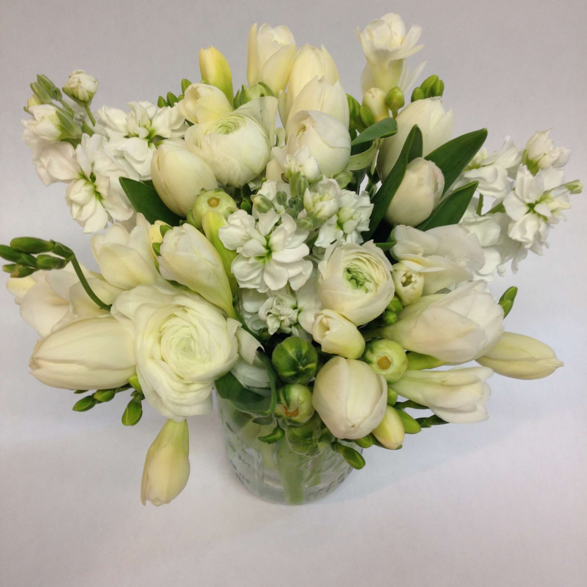 This elegant arrangement celebrates the timeless beauty of whites and greens, proving