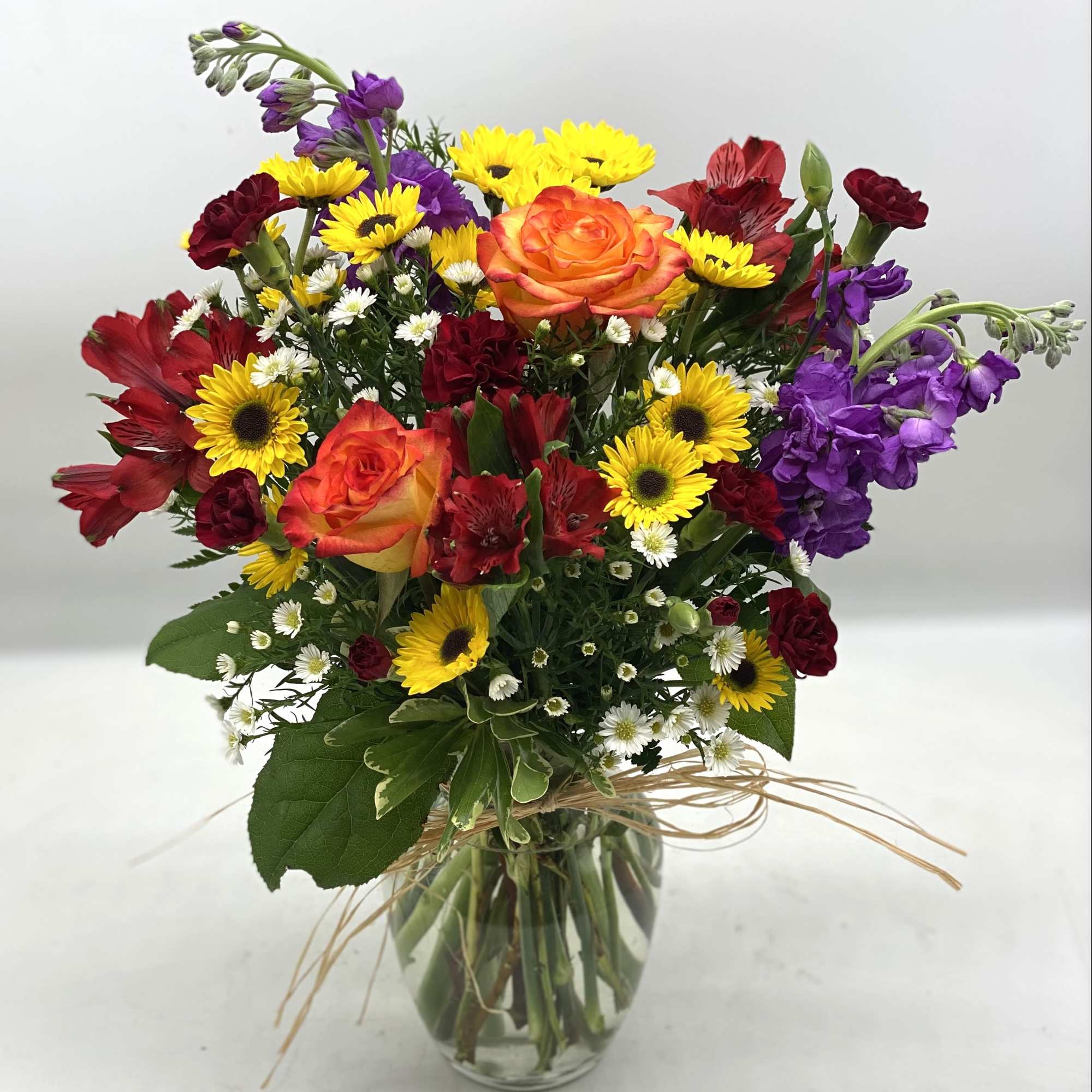 A mix of fall hues in a clear, glass vase finished off A mix of fall hues in a clear, glass vase finished off