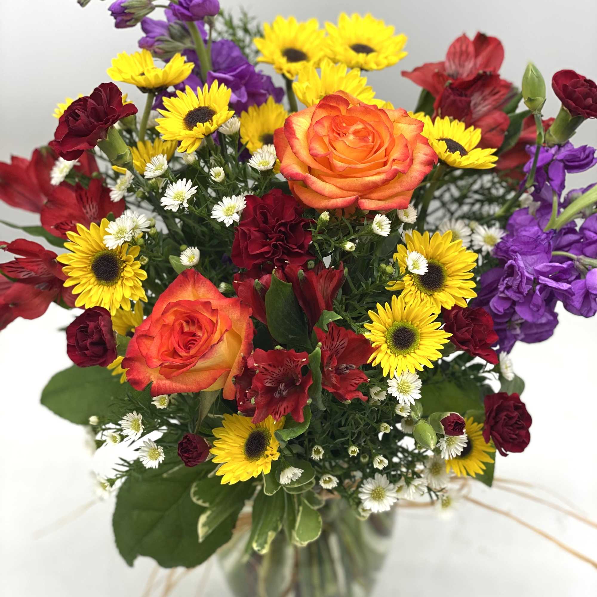 A mix of fall hues in a clear, glass vase finished off A mix of fall hues in a clear, glass vase finished off