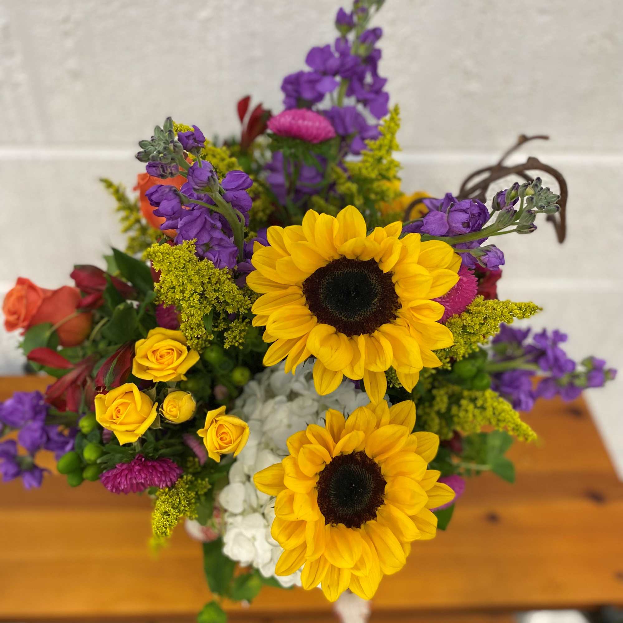 Mix of Fresh Blooms designed in a large gathering vase accented with