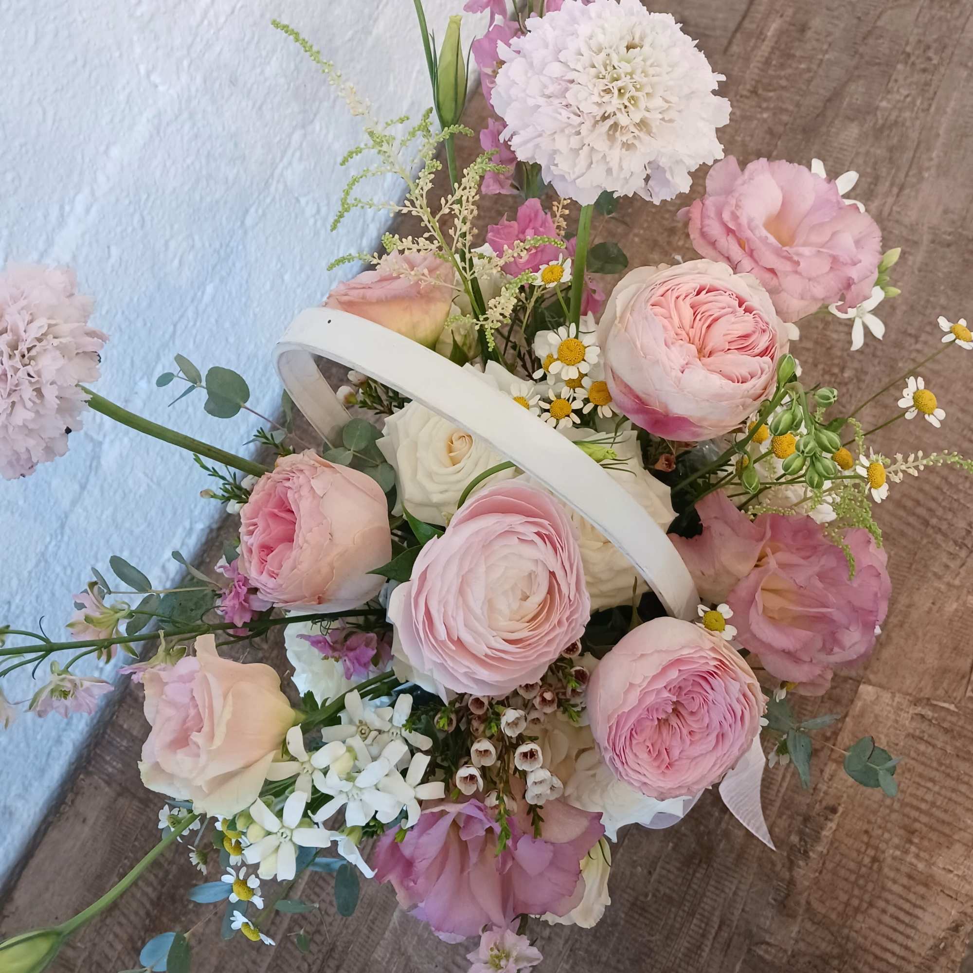 Designed in a basket, this arrangement overflows with soft shades of pink.