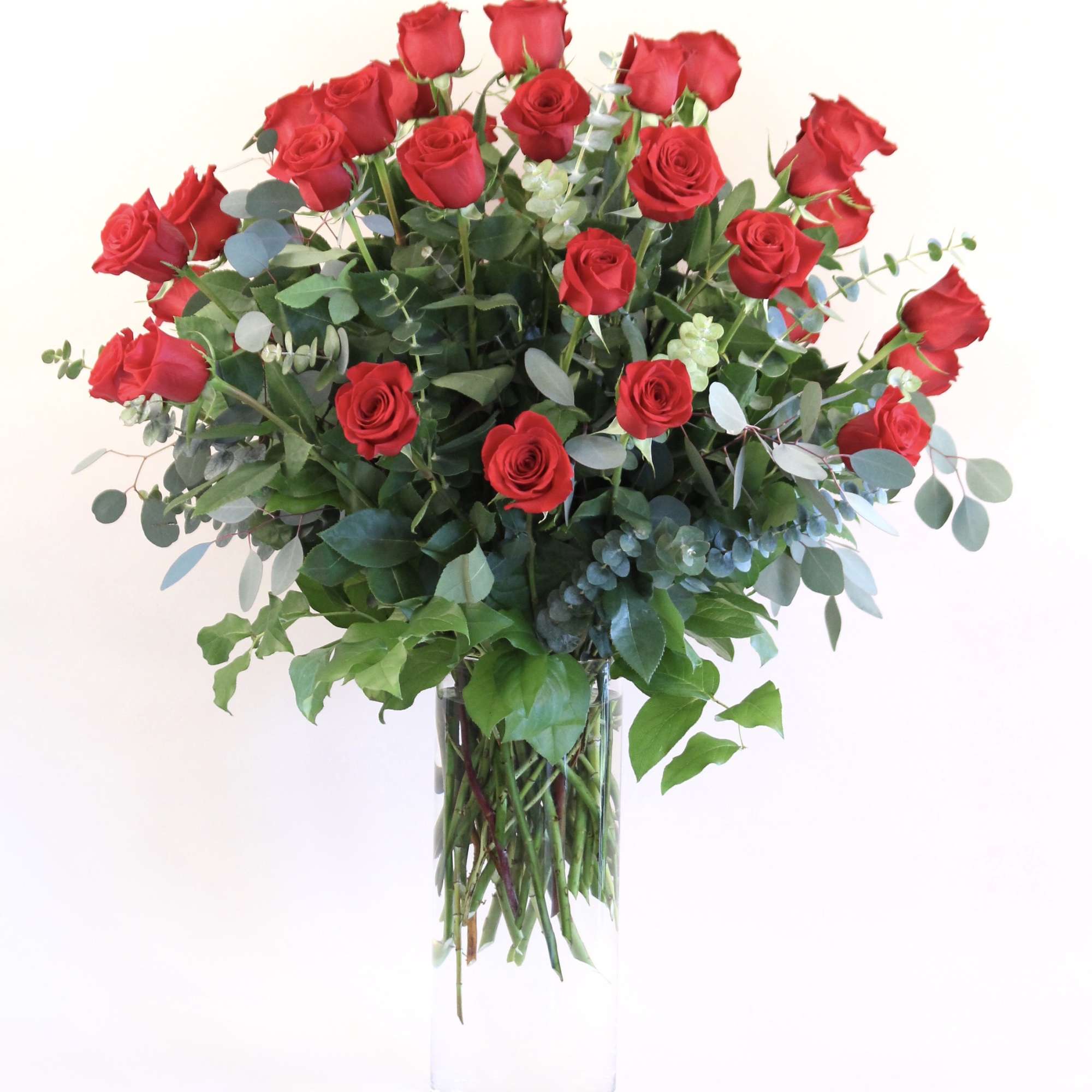 36 long stem red roses with mixed greenery in a clear cylinder