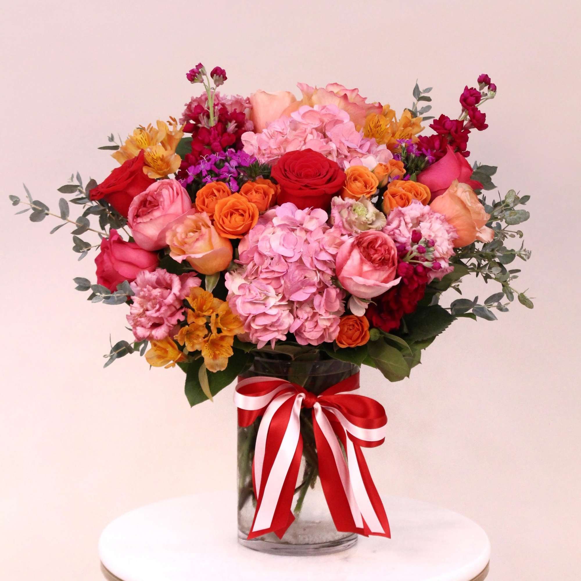 This beautiful arrangement with shades of red, pinks, purple, orange and magenta