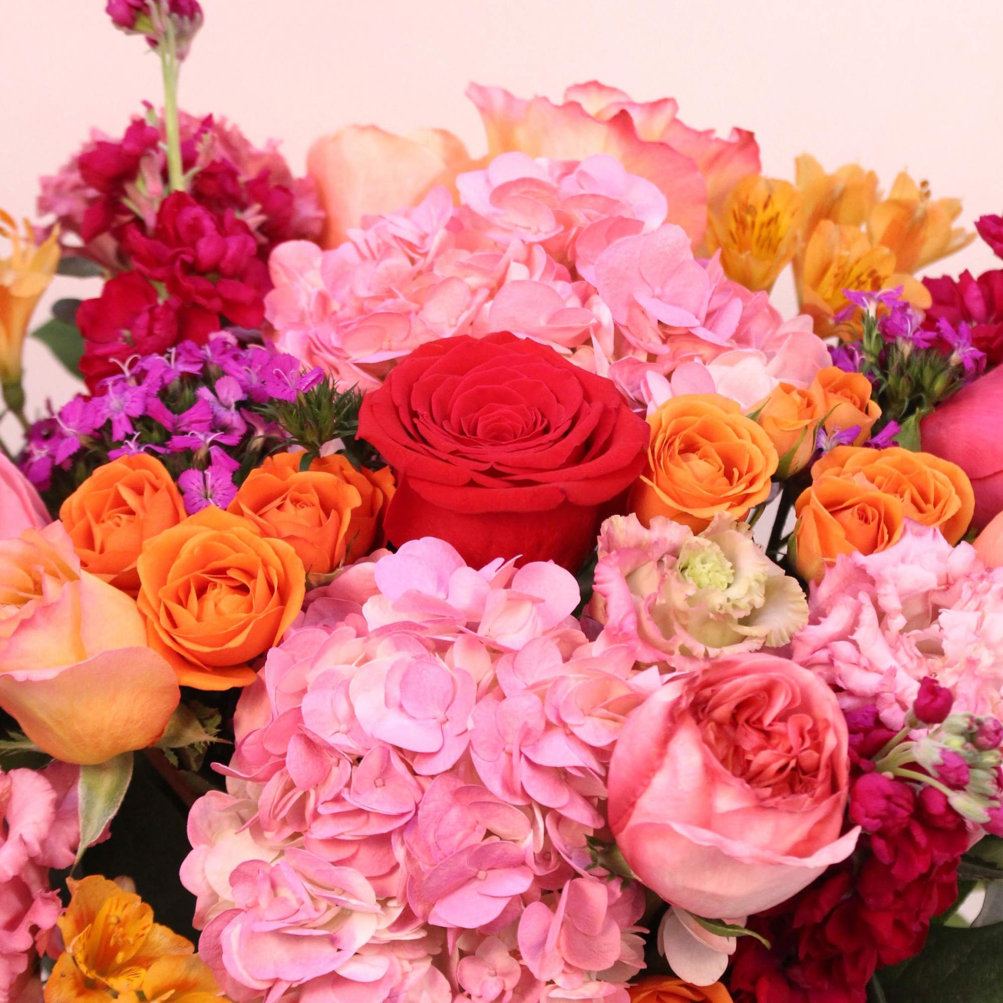 This beautiful arrangement with shades of red, pinks, purple, orange and magenta