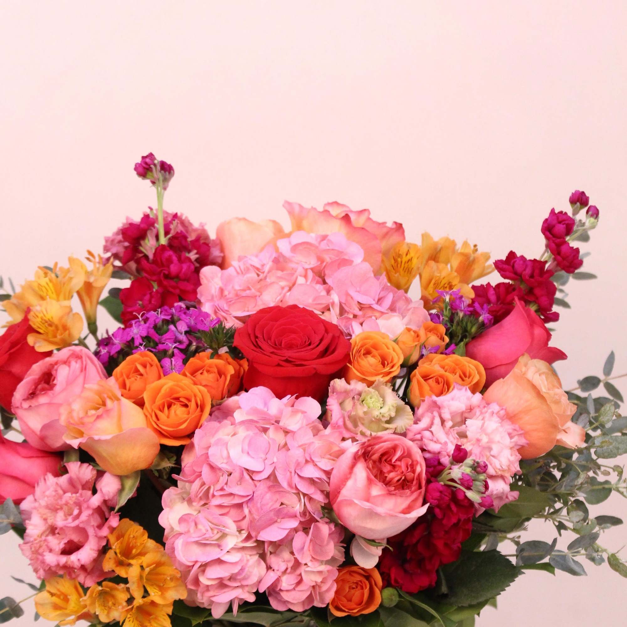 This beautiful arrangement with shades of red, pinks, purple, orange and magenta
