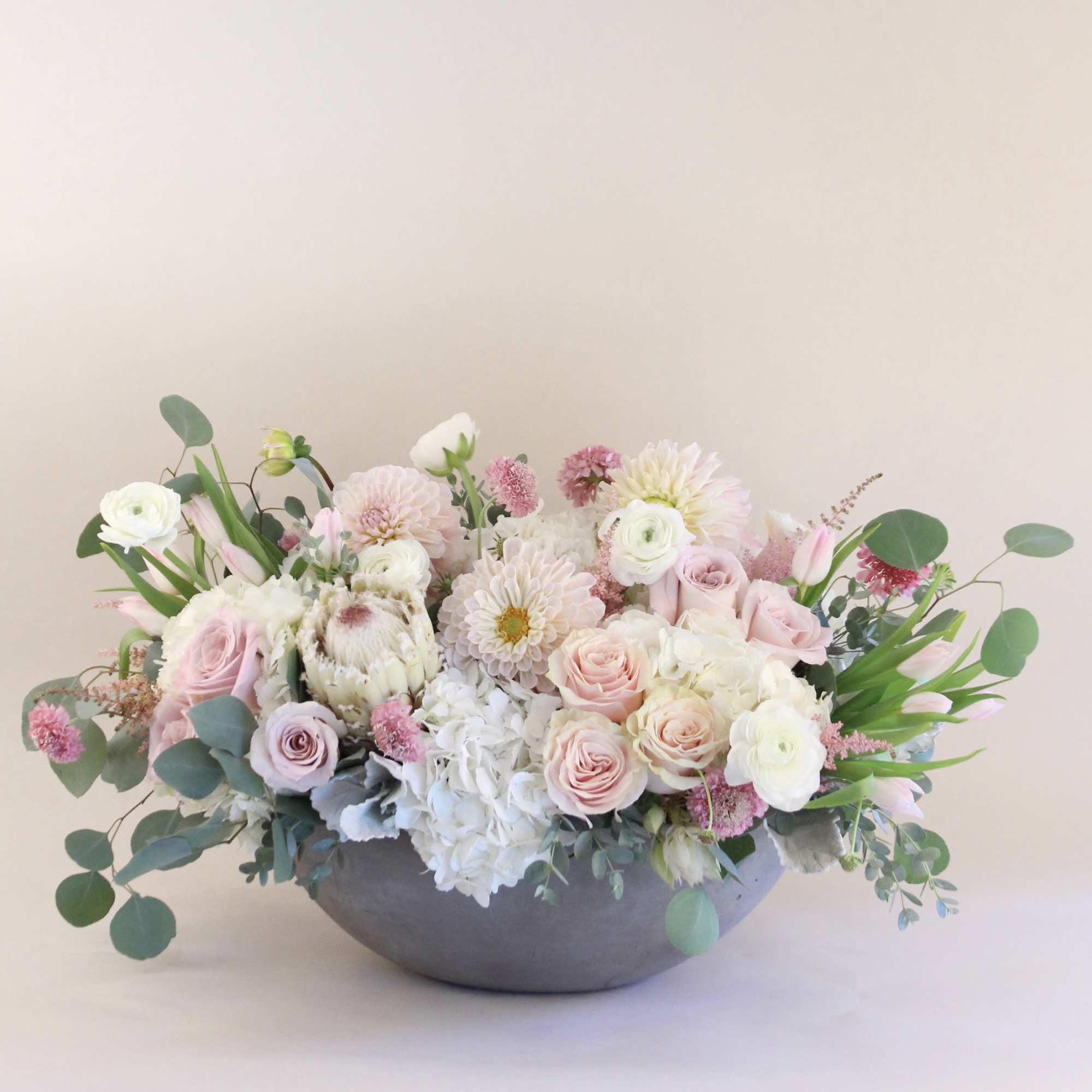 A very lush arrangement of blush, pinks and white in a ceramic