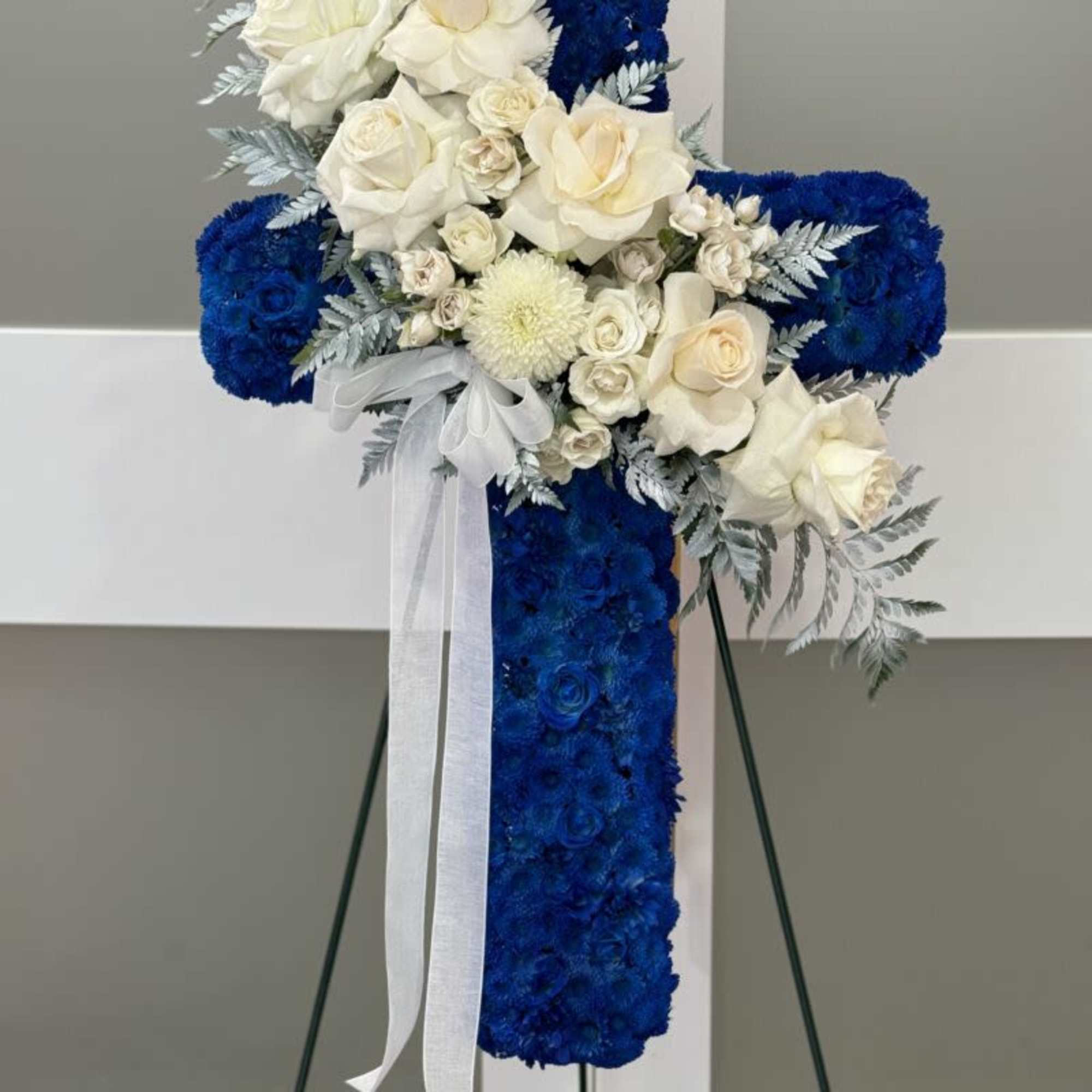 Show your condolences with our modern freestanding floral cross. It includes 
