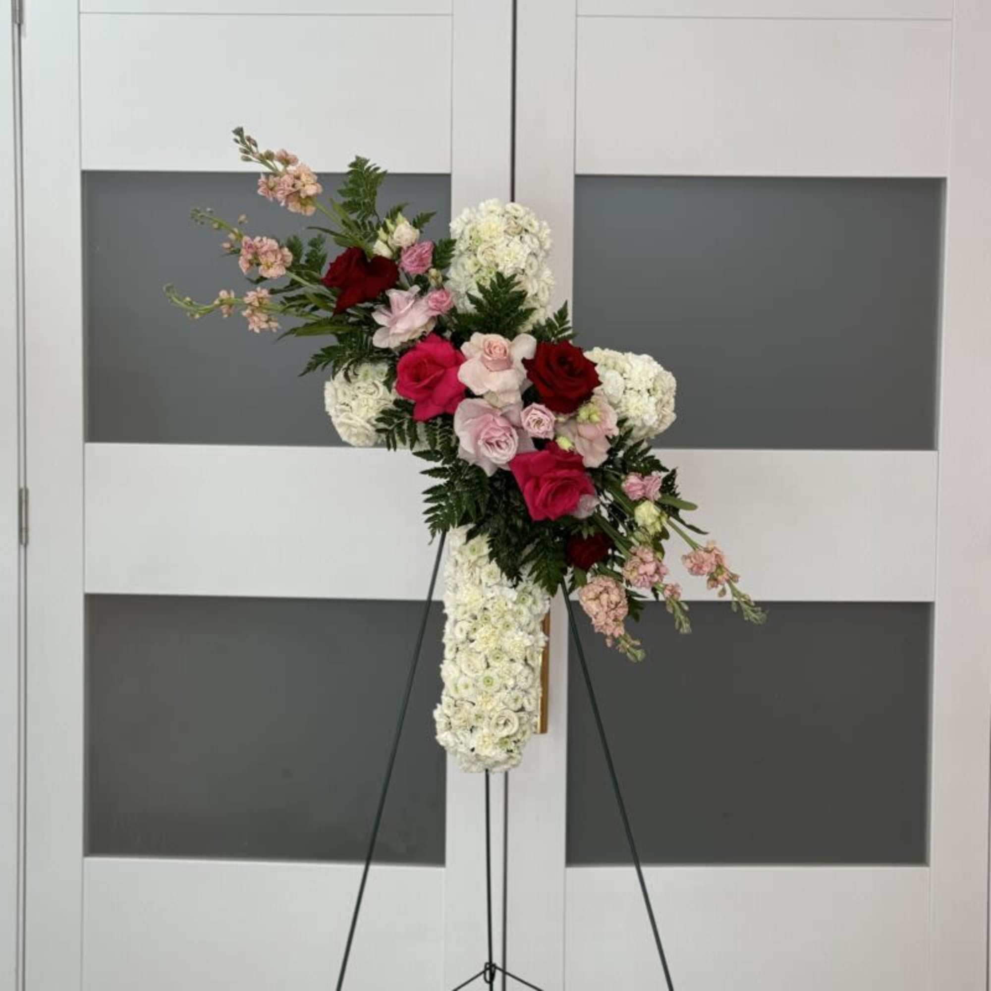 Show your condolences with our modern freestanding floral cross. It includes 