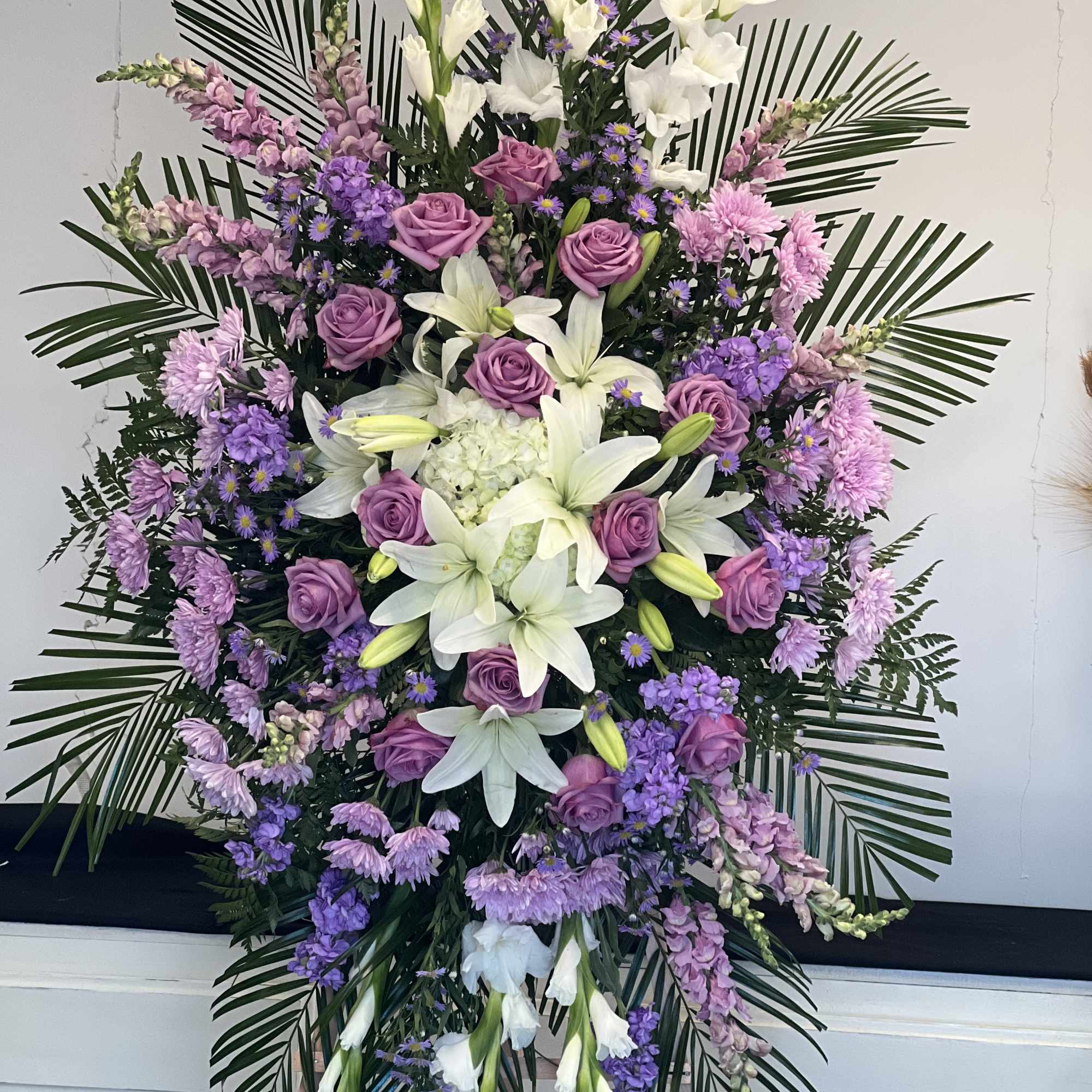 Send a beautiful Lavender floral standing spray as a symbol of your