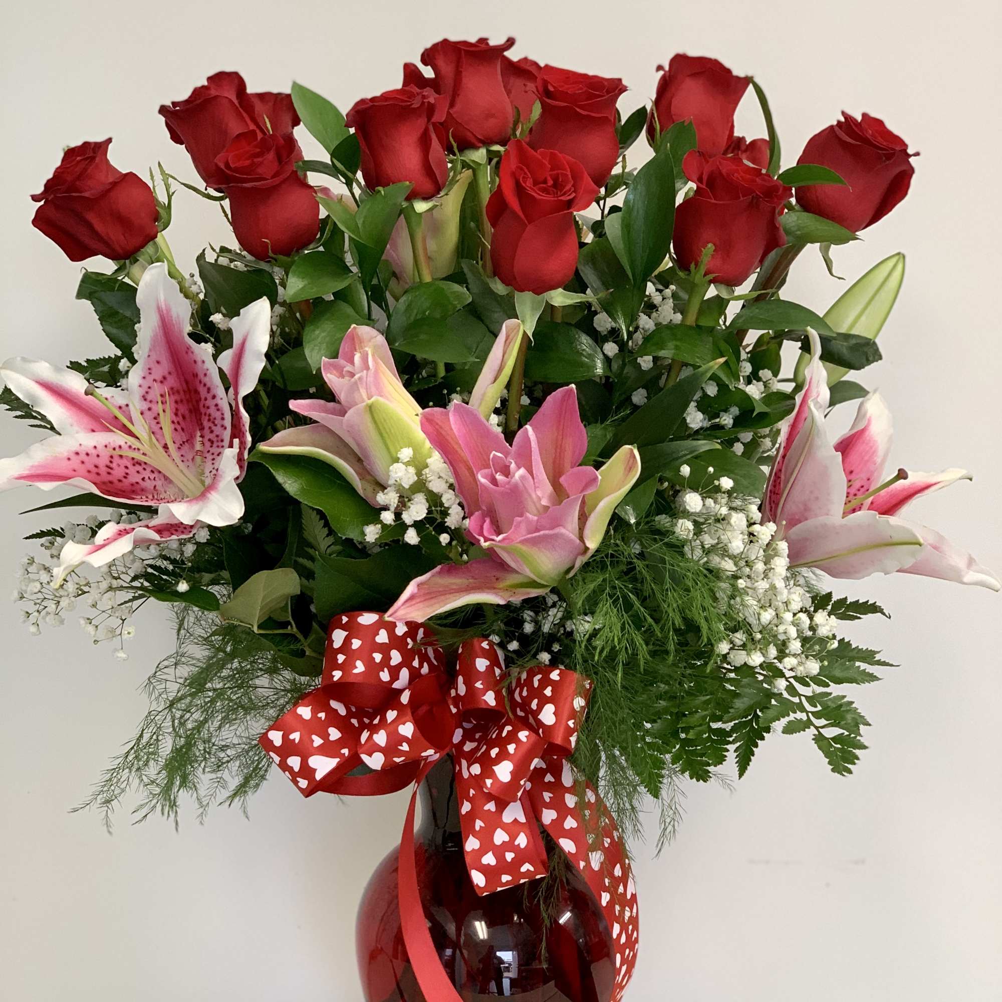Pink lilies arranged with dozen red roses Pink lilies arranged with dozen red roses