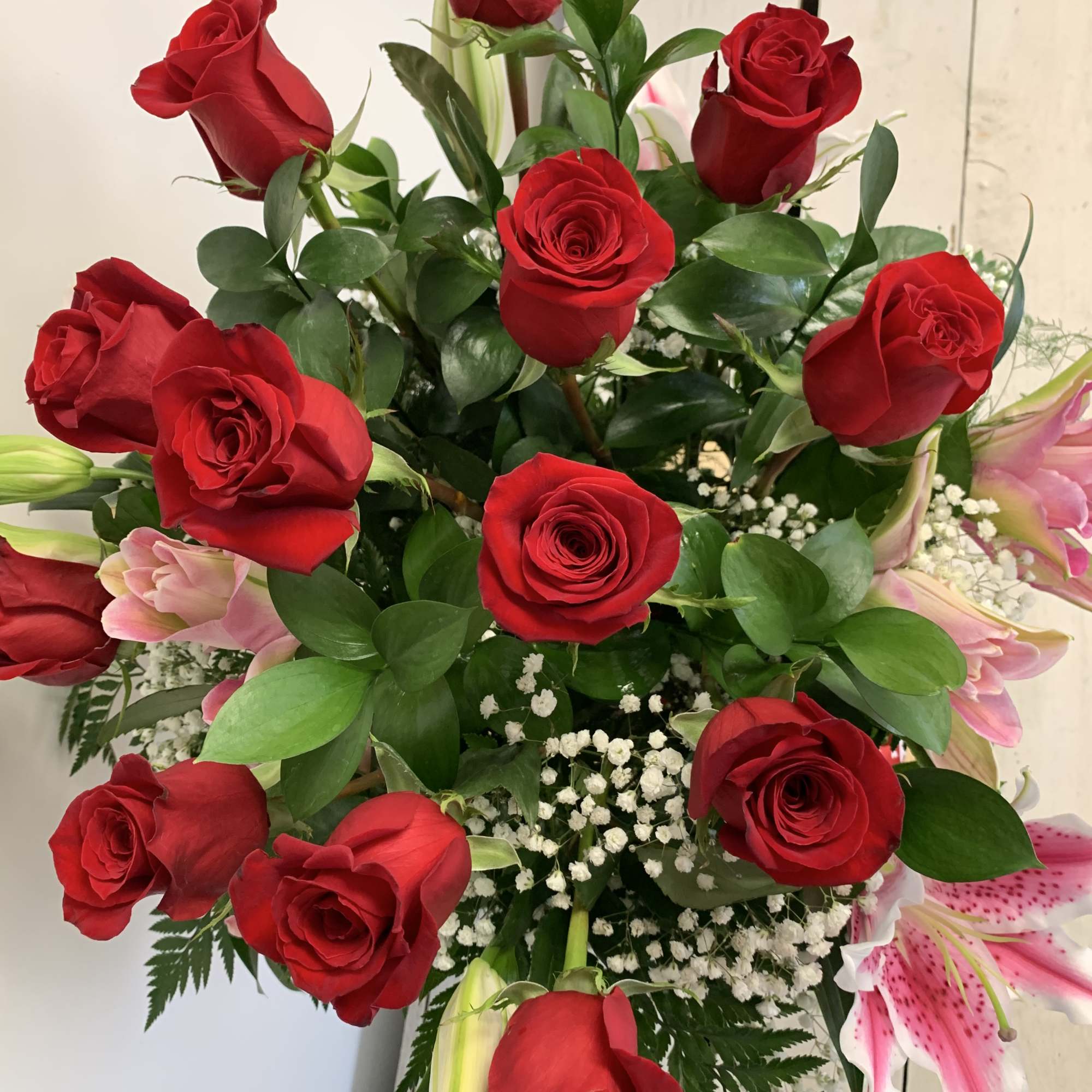 Pink lilies arranged with dozen red roses Pink lilies arranged with dozen red roses