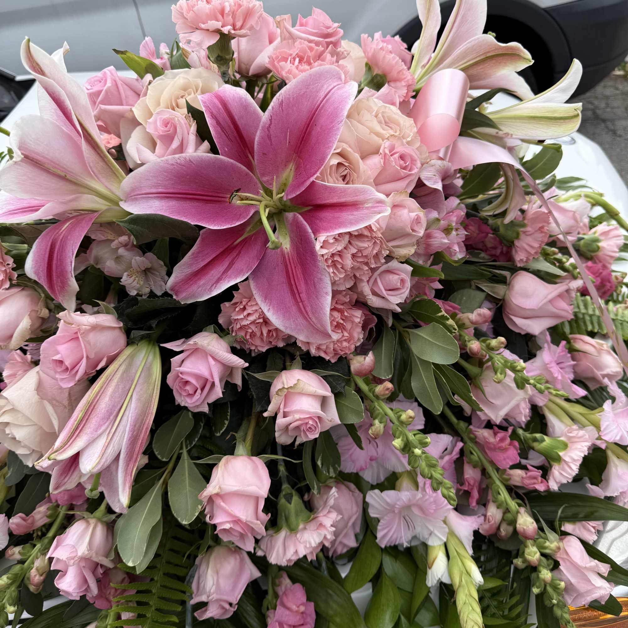 Pink lilies, roses &amp; pink gladiolus arrangement placed on top of the