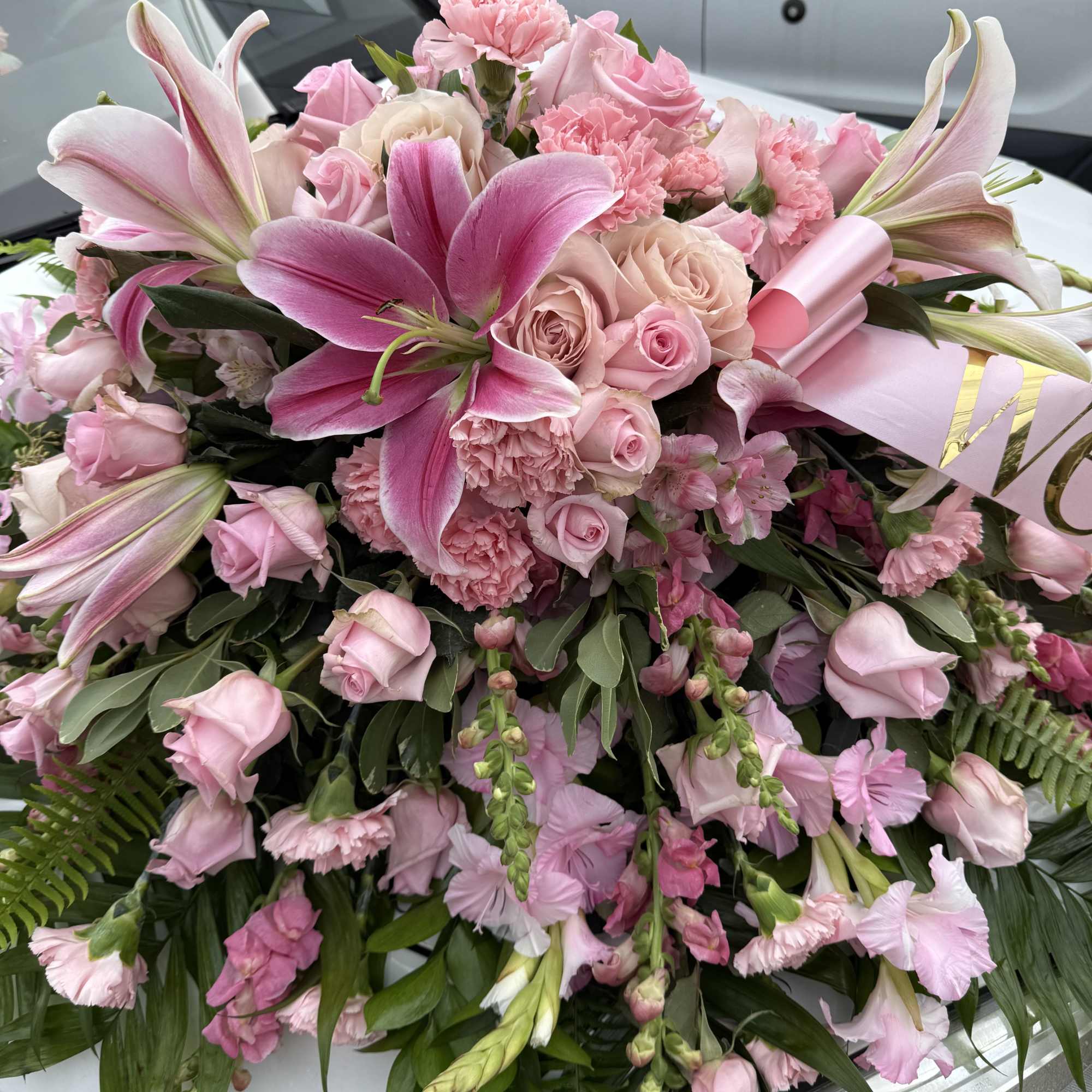 Pink lilies, roses &amp; pink gladiolus arrangement placed on top of the