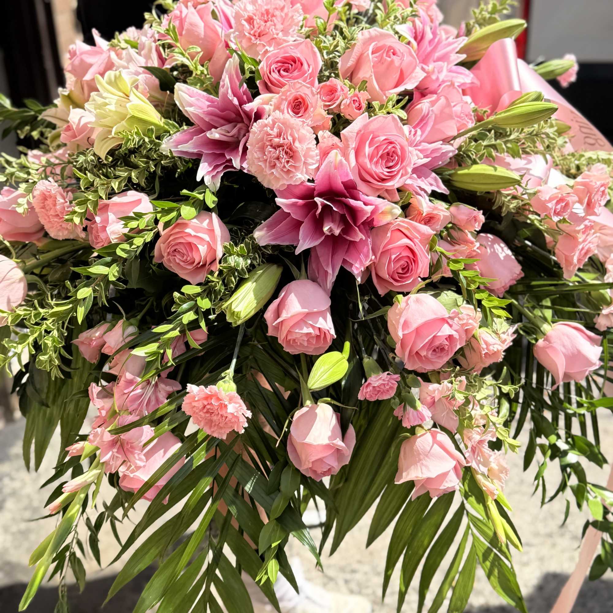 Pink lilies, roses &amp; pink gladiolus arrangement placed on top of the