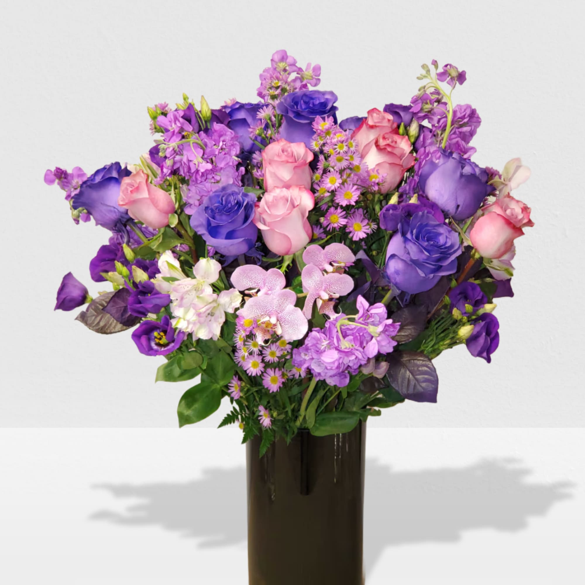 Cylinder vase with a mix of purple flowers 