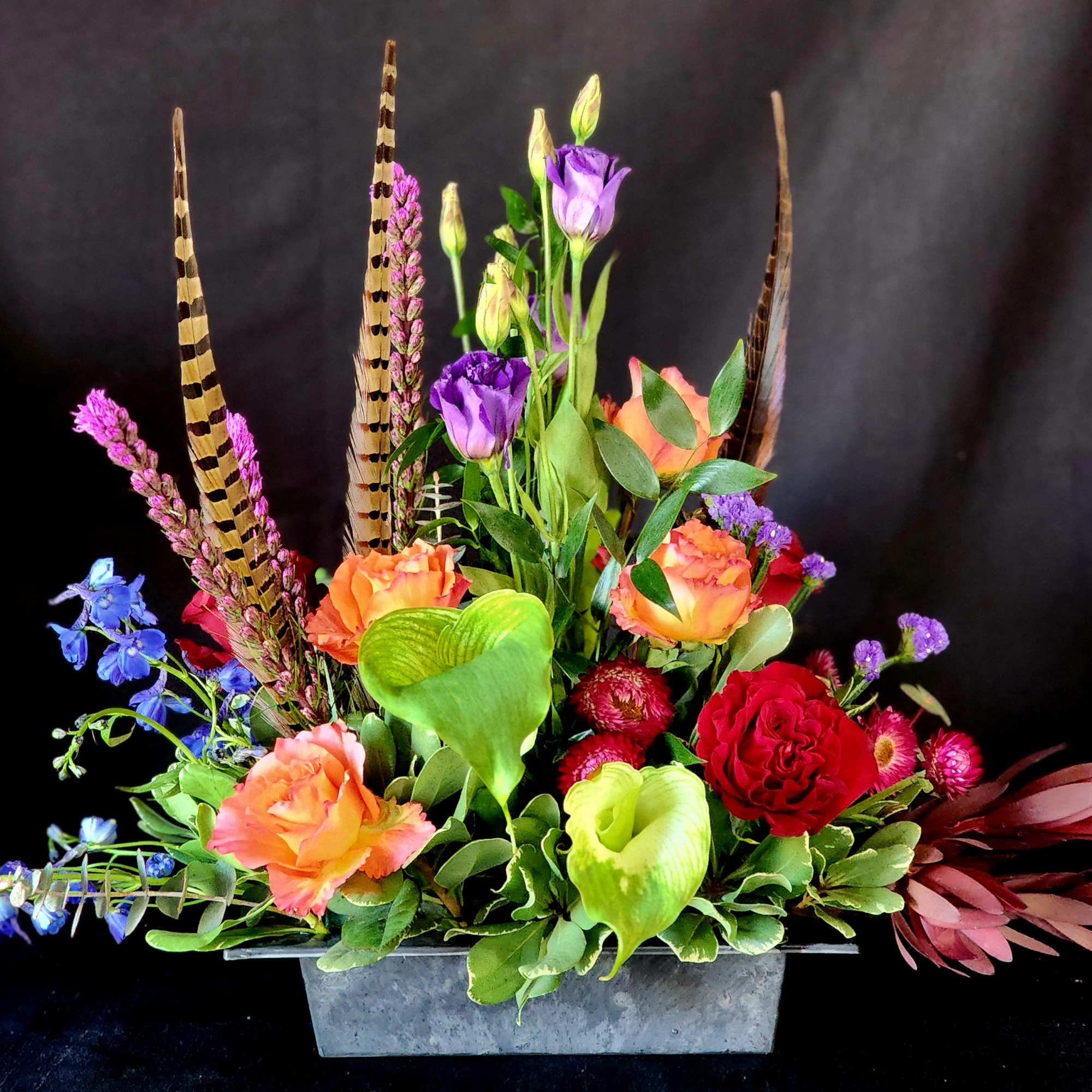 **One week notice required.**
Free Spirit roses and seasonal flowers with feathers to