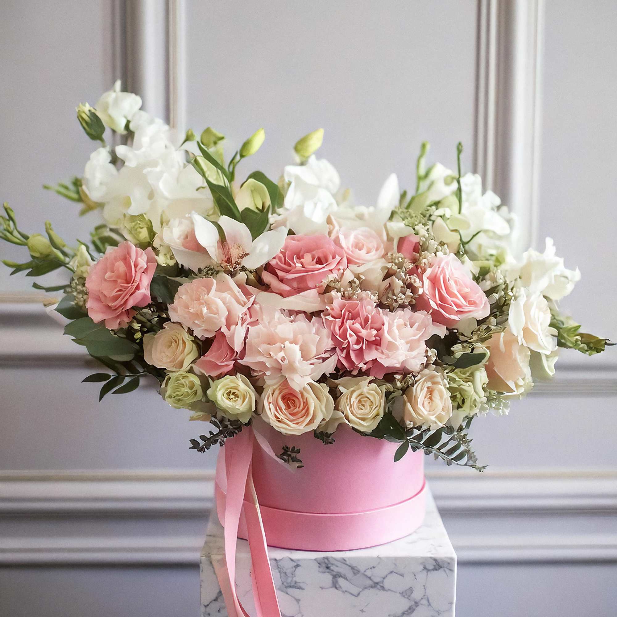 The arrangement features a stunning mix of flowers, including white and peach