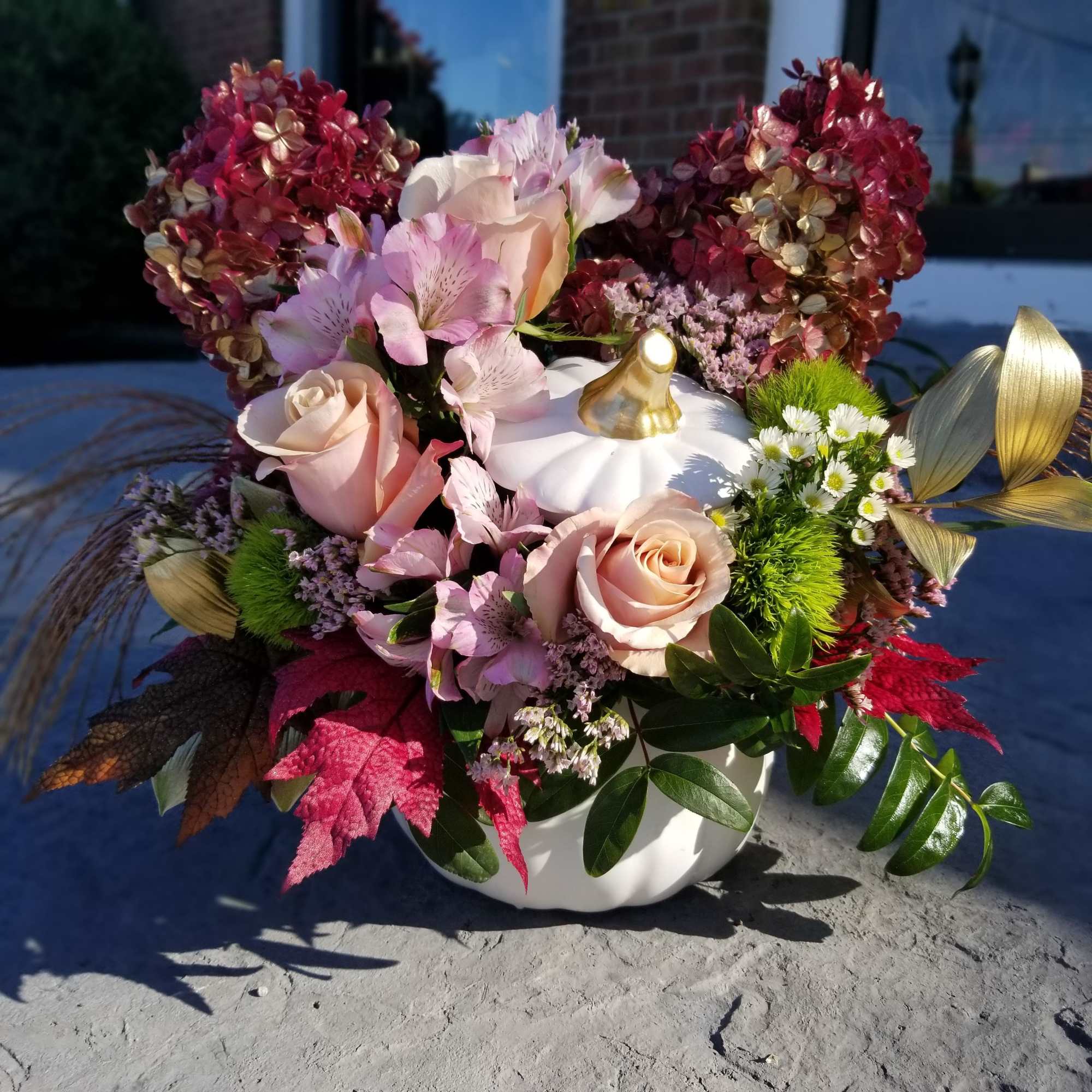 Designed in a white ceramic pumpkin.  Flowers chosen for this royal