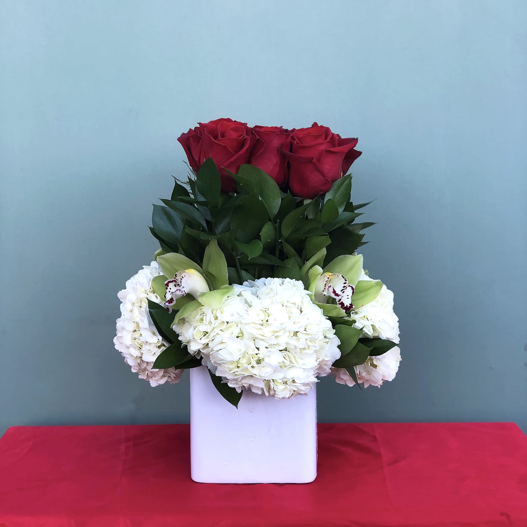 An arrangement of roses and orchids designed with love for your most