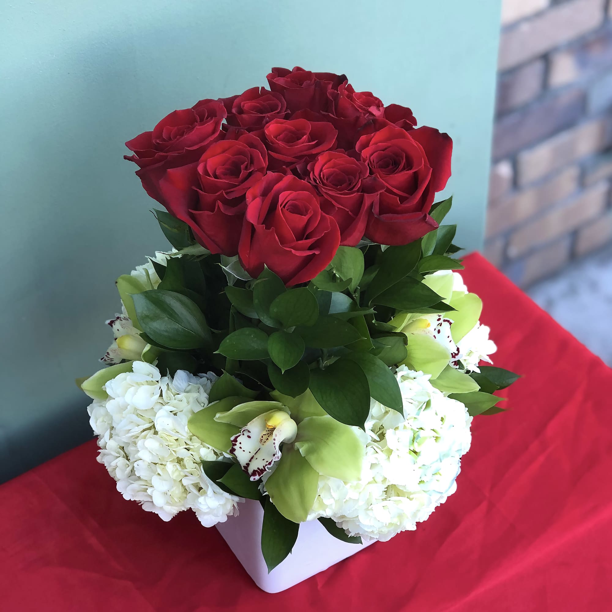 An arrangement of roses and orchids designed with love for your most