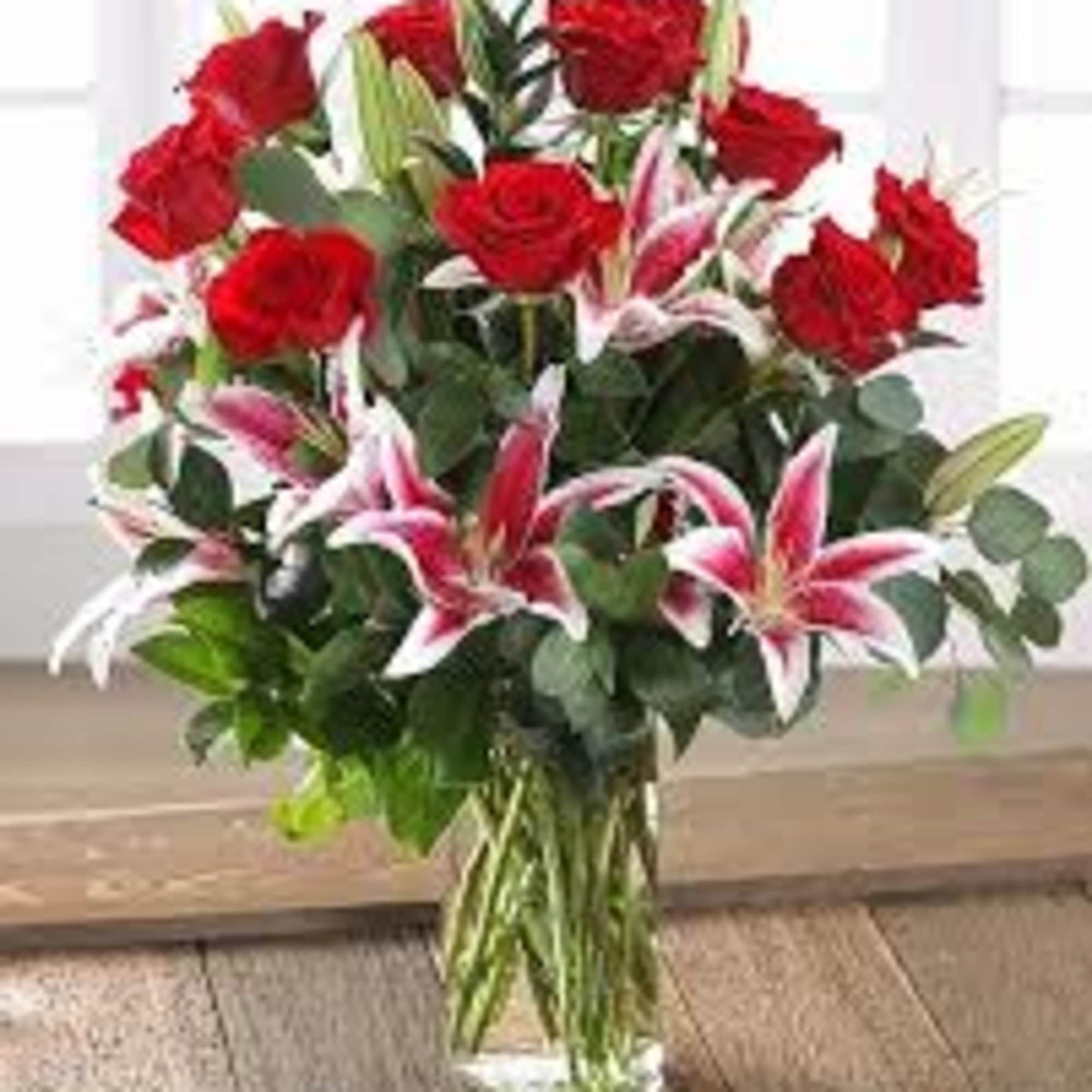 on a  vase with roses and star gazers