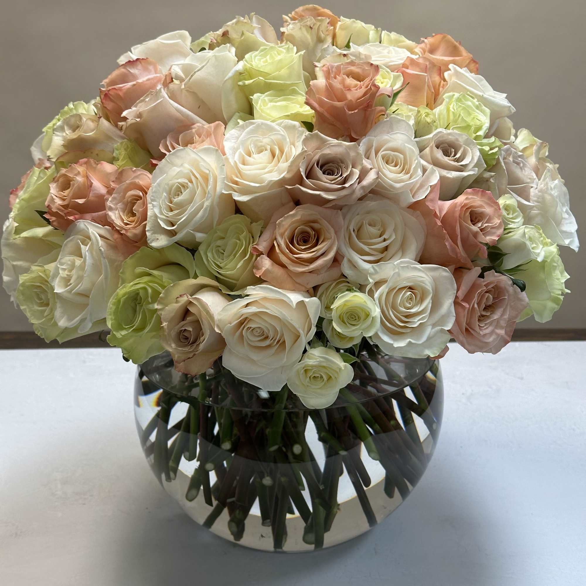 A beautiful mix of pastel roses, arranged in a tight and modern