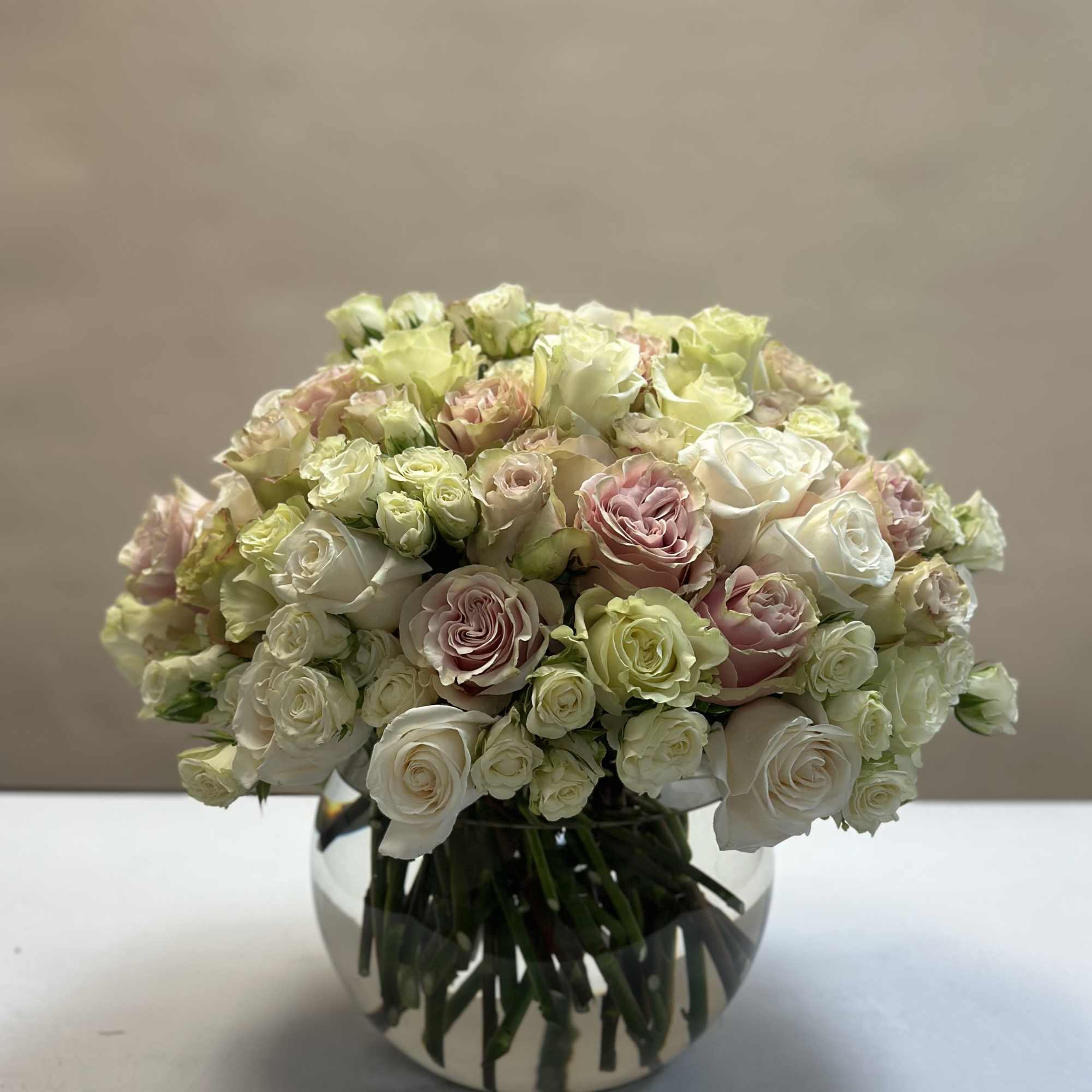 A beautiful mix of pastel roses, arranged in a tight and modern