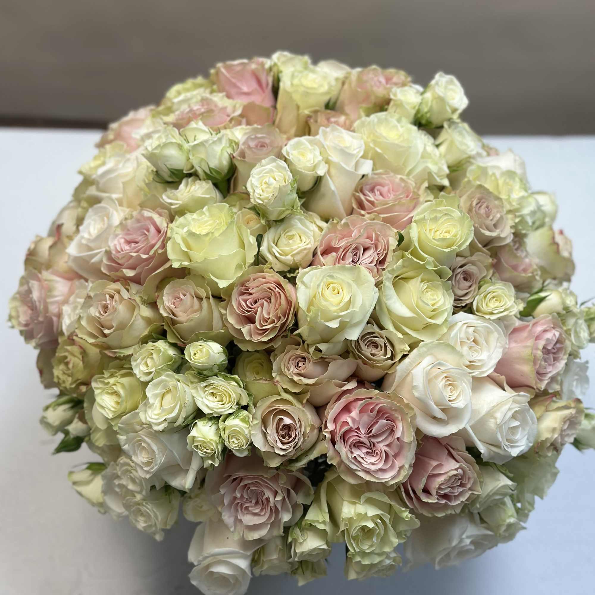 A beautiful mix of pastel roses, arranged in a tight and modern