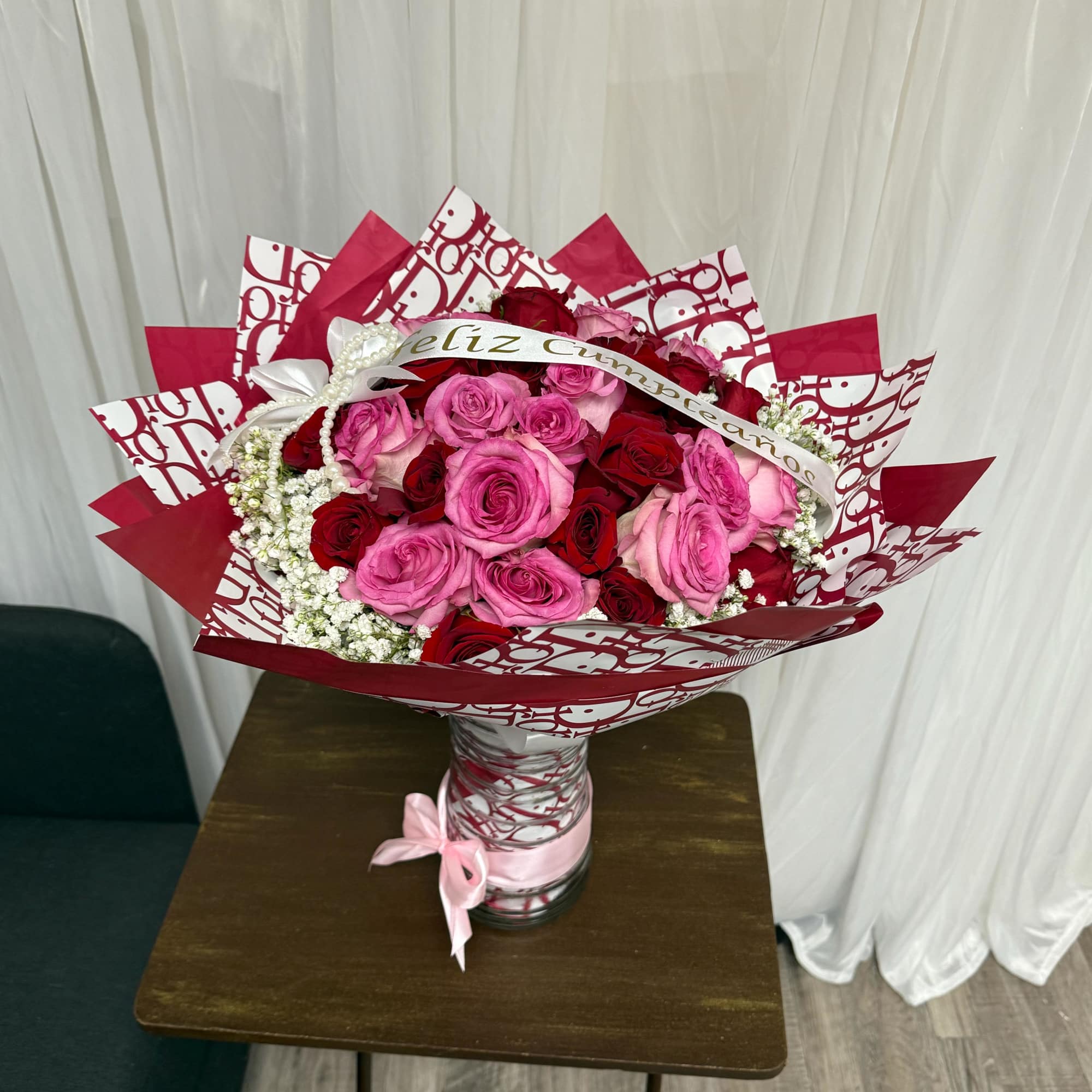  An elegant arrangement of pink and red roses, accented with delicate