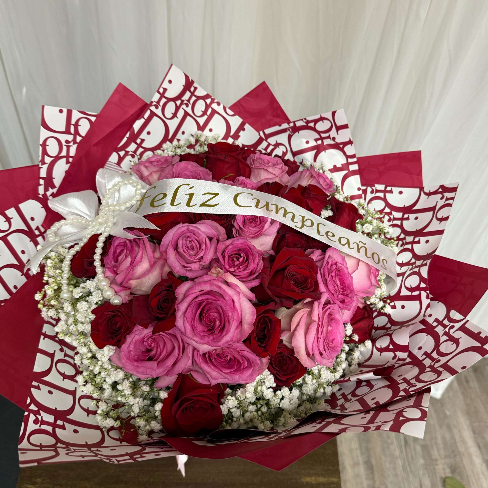  An elegant arrangement of pink and red roses, accented with delicate