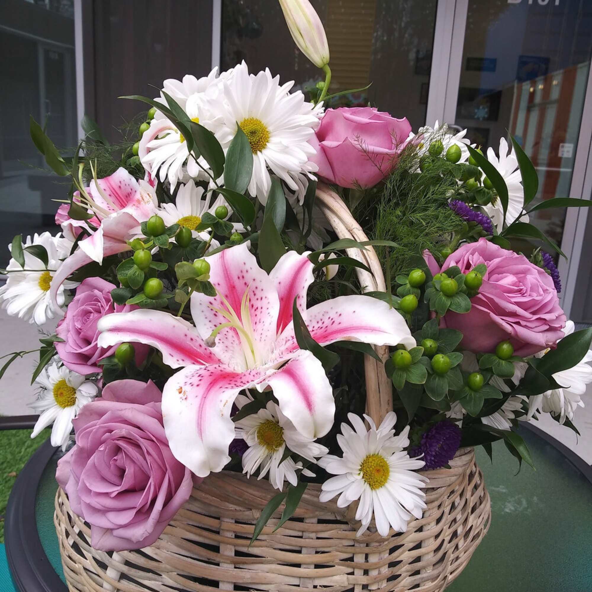 A handled basket filled with, roses, pink stargazer lillies, daisy mums, Monte A handled basket filled with, roses, pink stargazer lillies, daisy mums, Monte