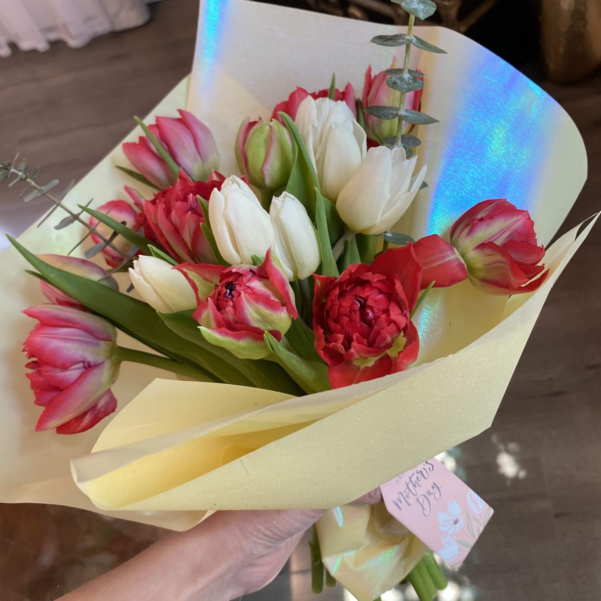 Tulips and eucalyptus,  in small bouquet wrapped.  Glass vase not