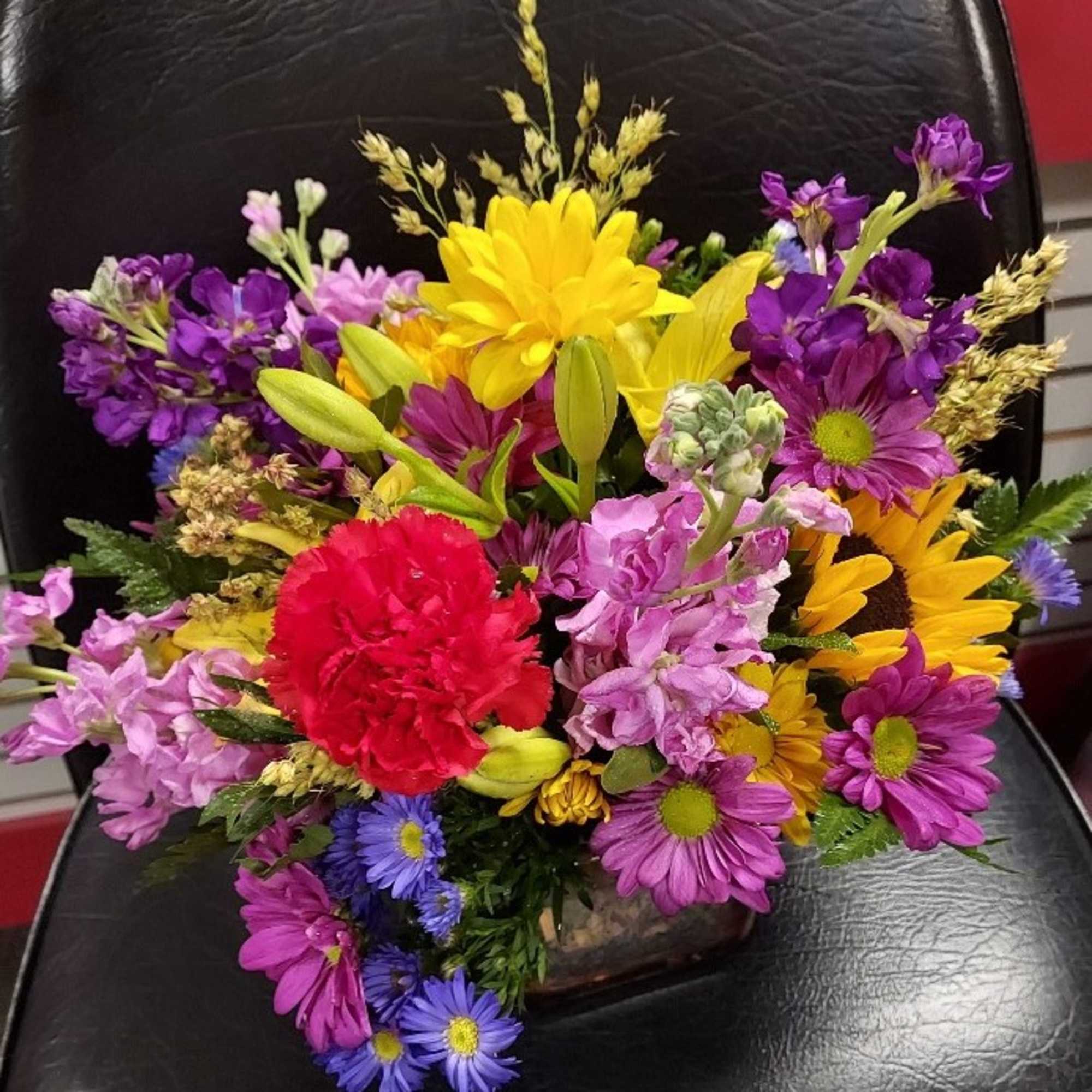 Bright colorful blooms in a sleek glass cube. This arrangement is perfect