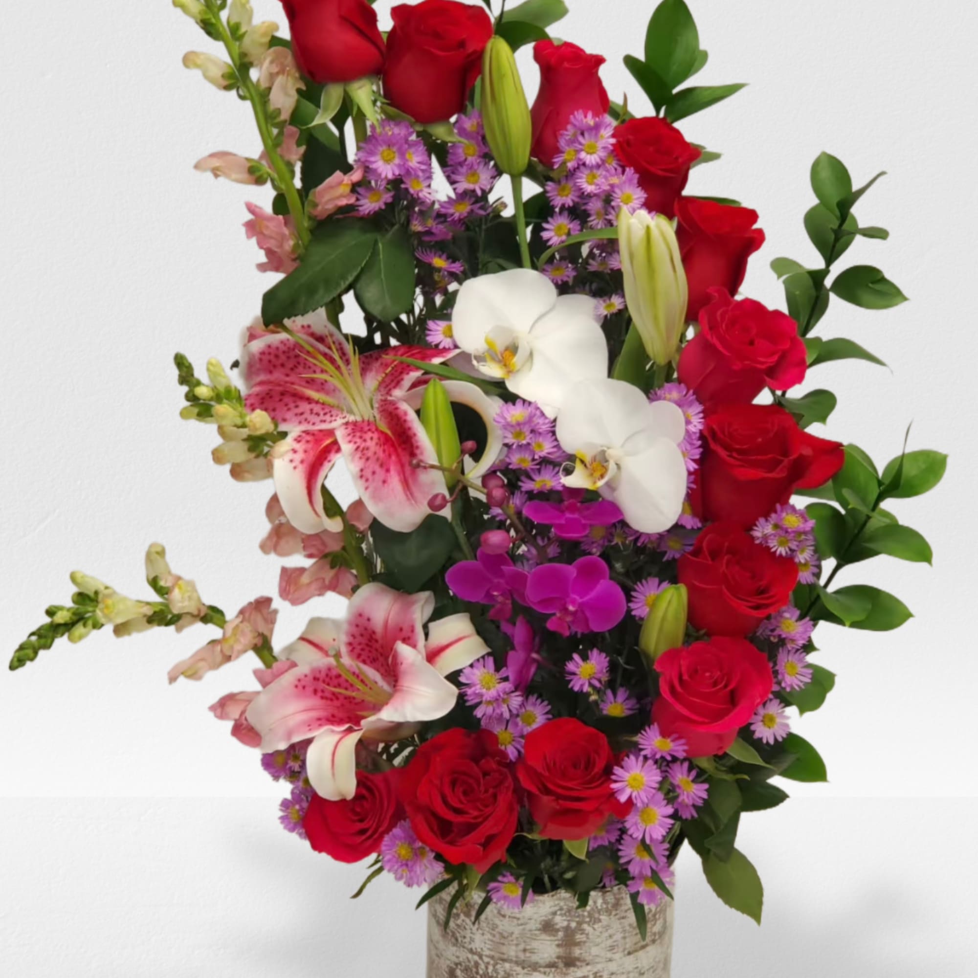 Hot pink and red roses, pink snaps and orchids arrange in a