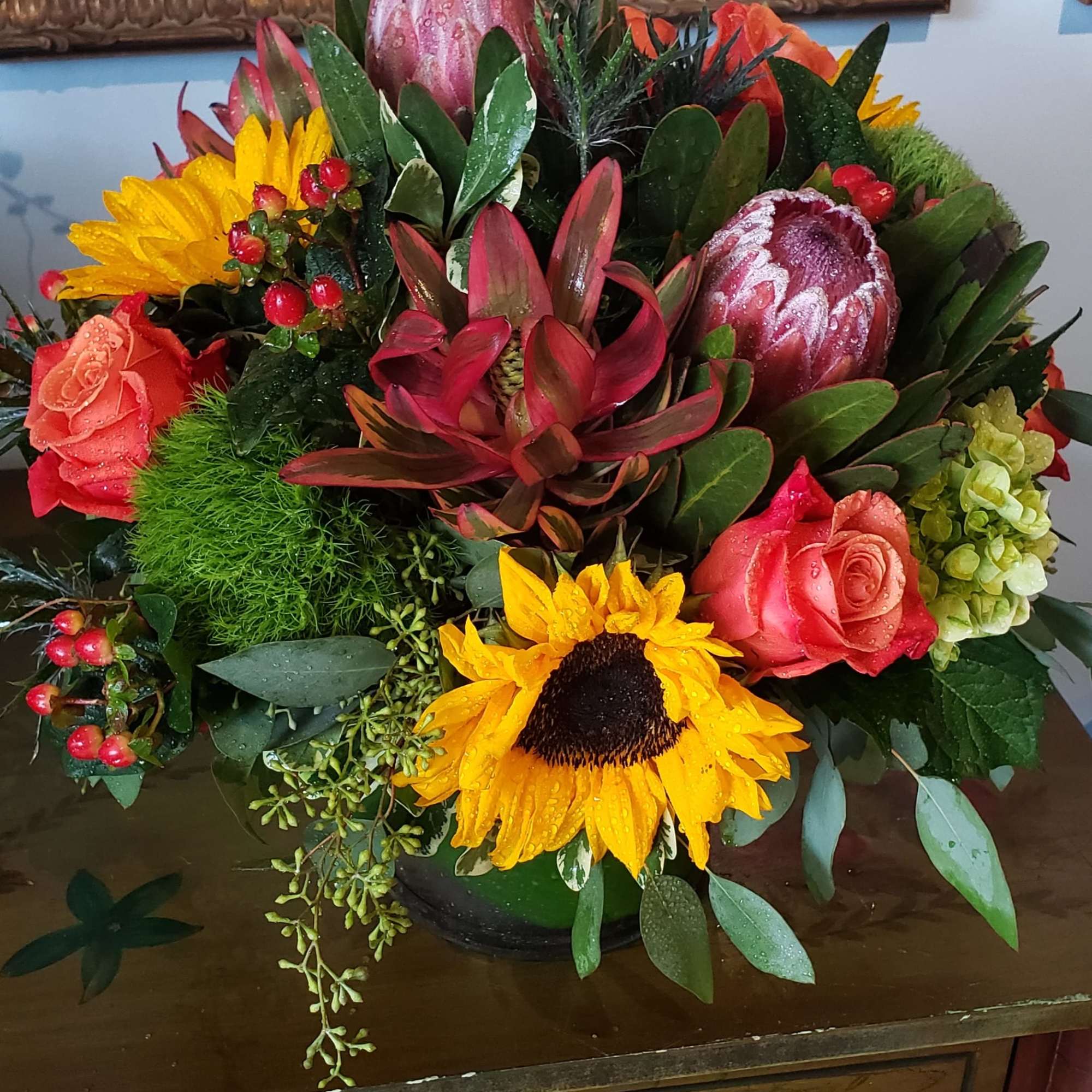 An elegant gathering vase filled with seasonal bright flowers such as 