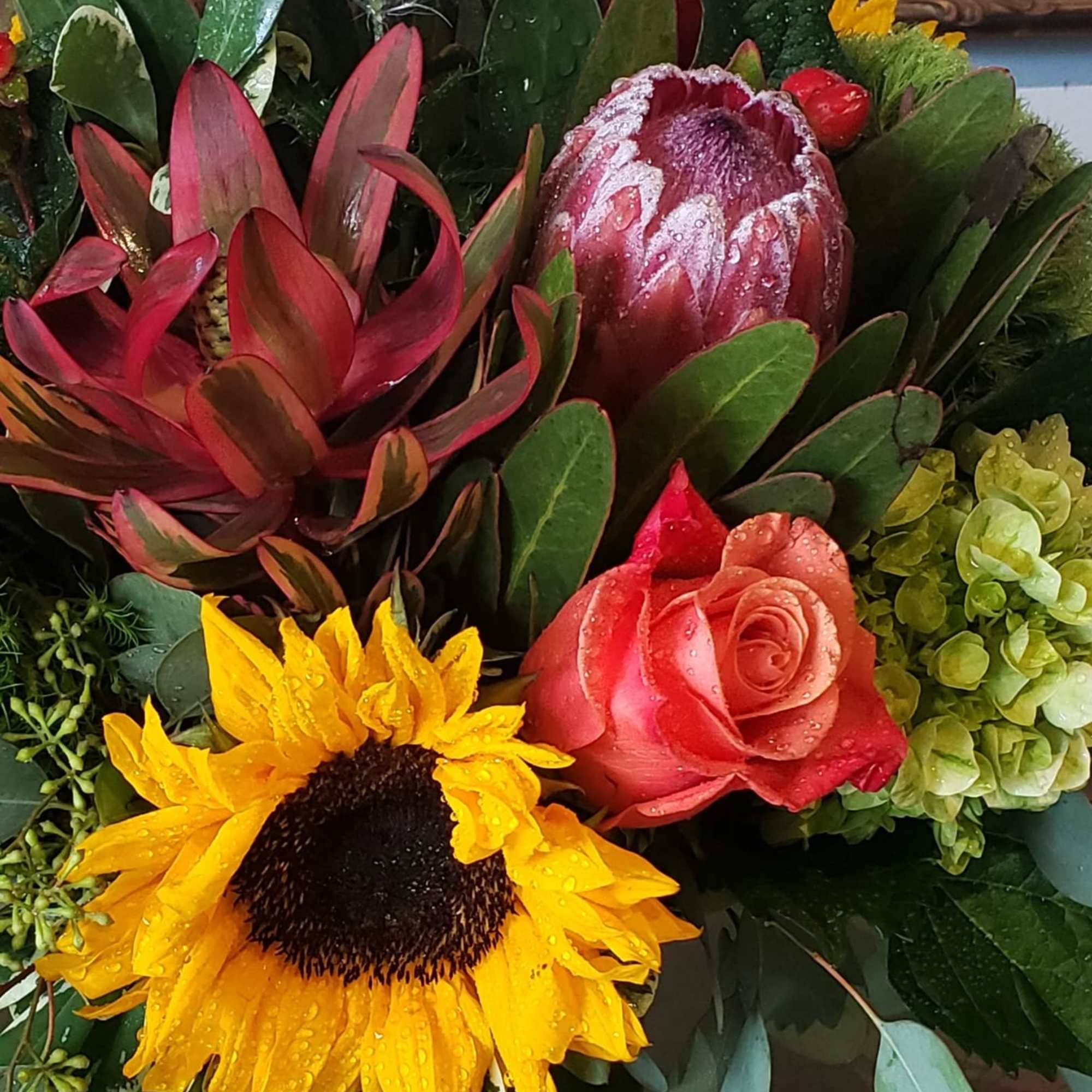 An elegant gathering vase filled with seasonal bright flowers such as 