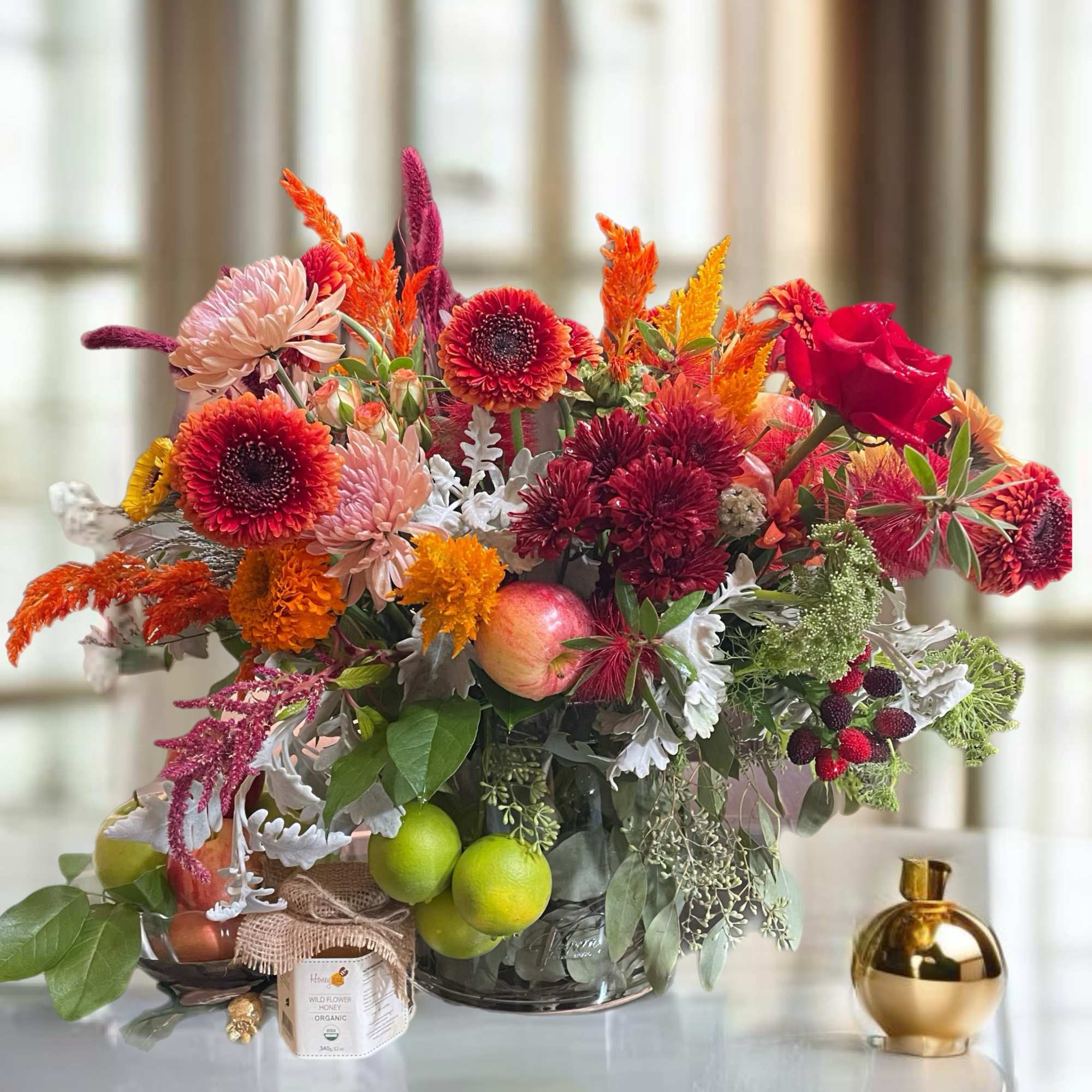 This arrangement in an elegant vase, with the orchids artfully displayed alongside