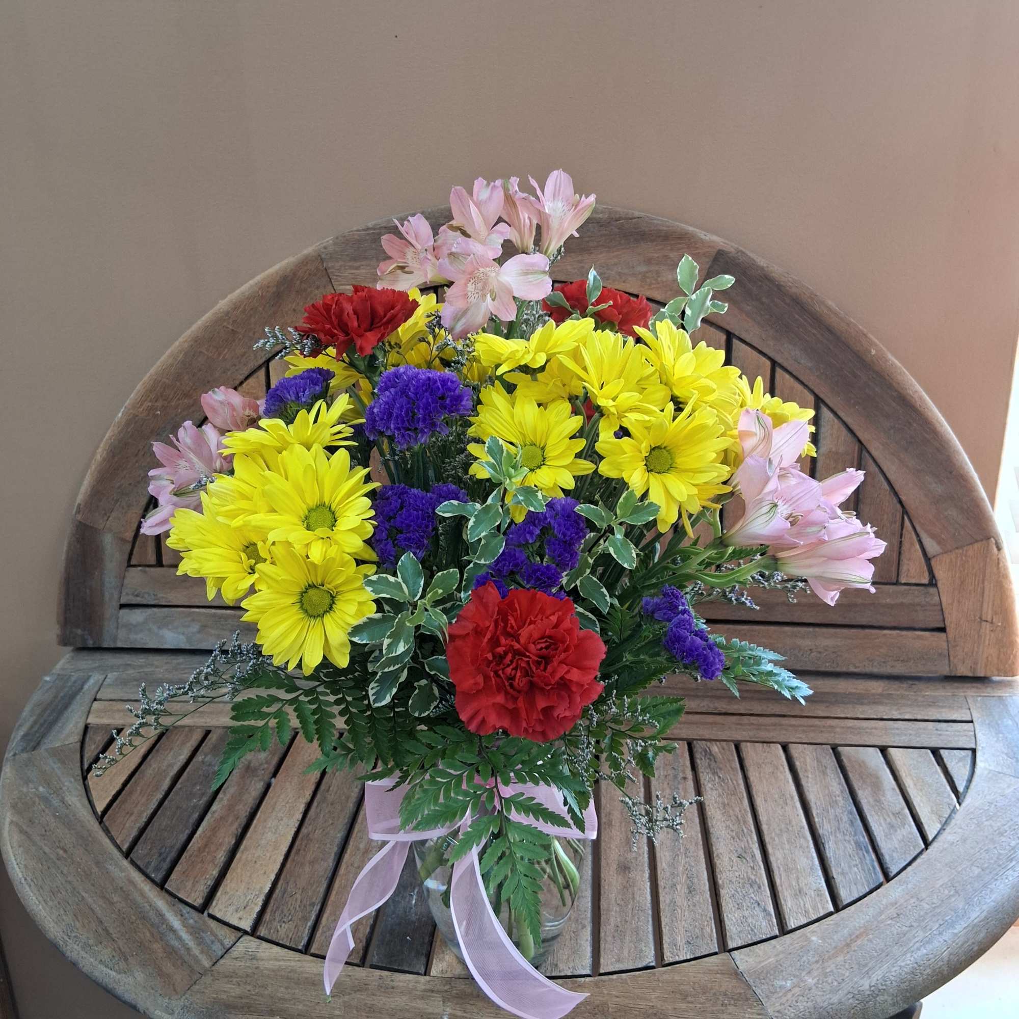 Vase full of vibrant colored flowers.