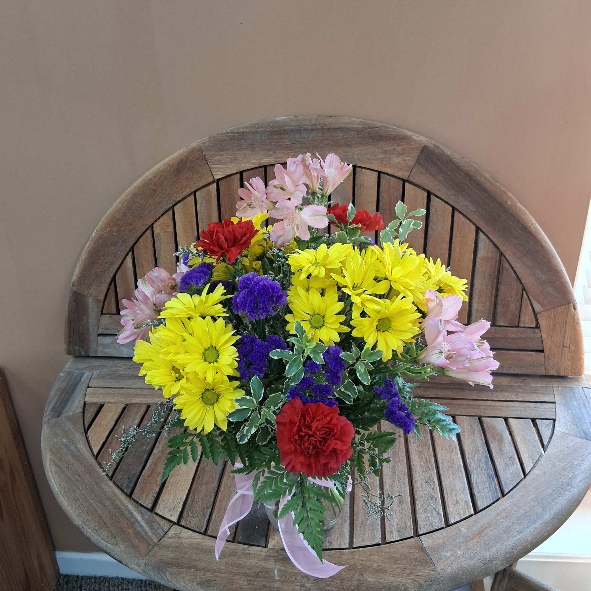 Vase full of vibrant colored flowers.