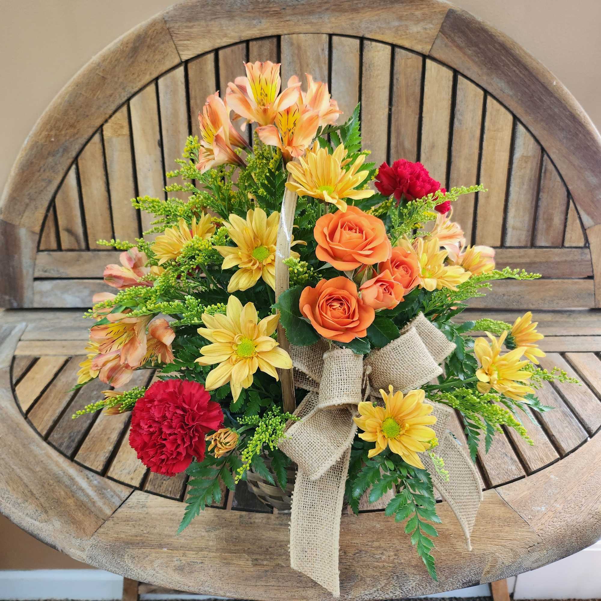 Mixed fall flowers in basket. Shades of flowers will vary.