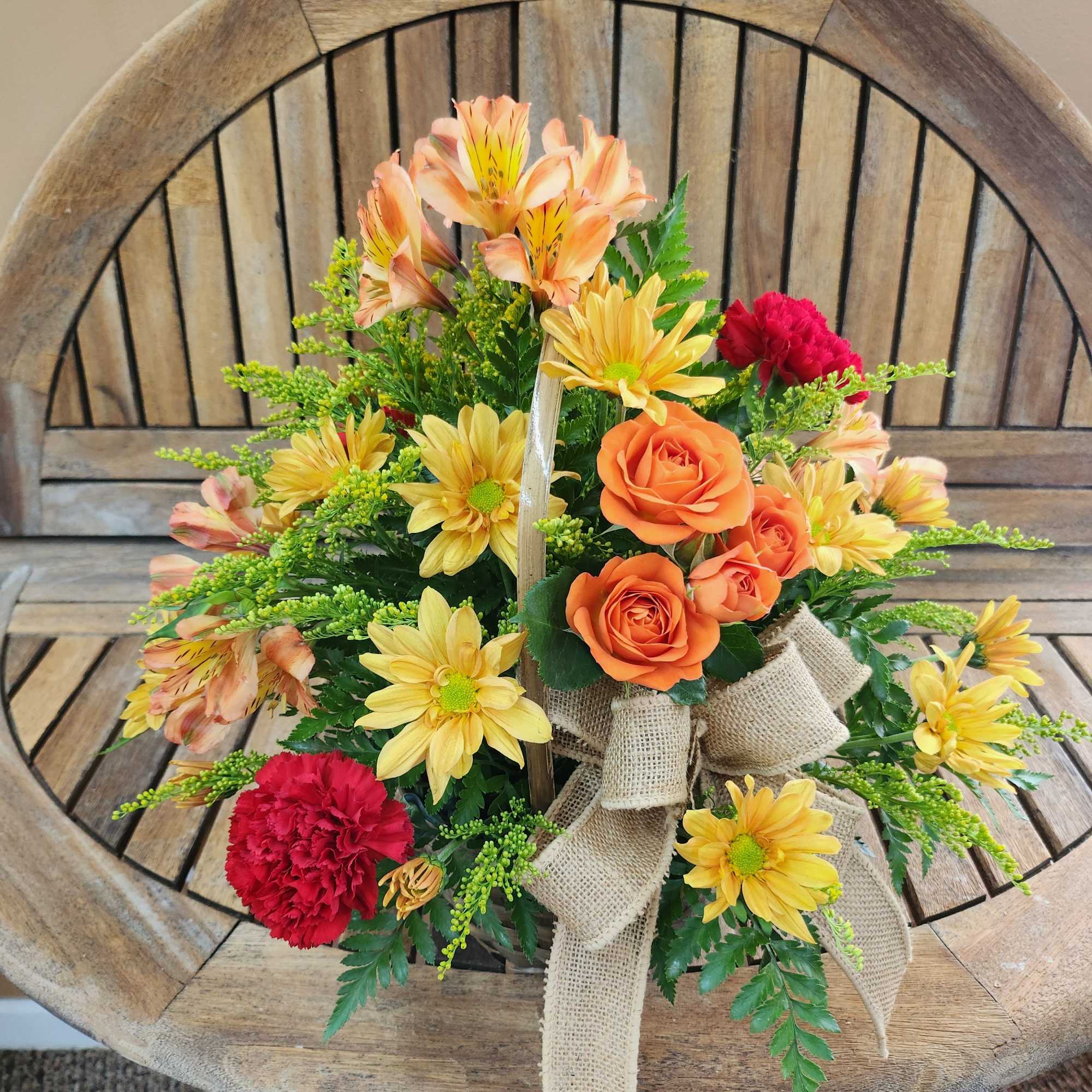 Mixed fall flowers in basket. Shades of flowers will vary.