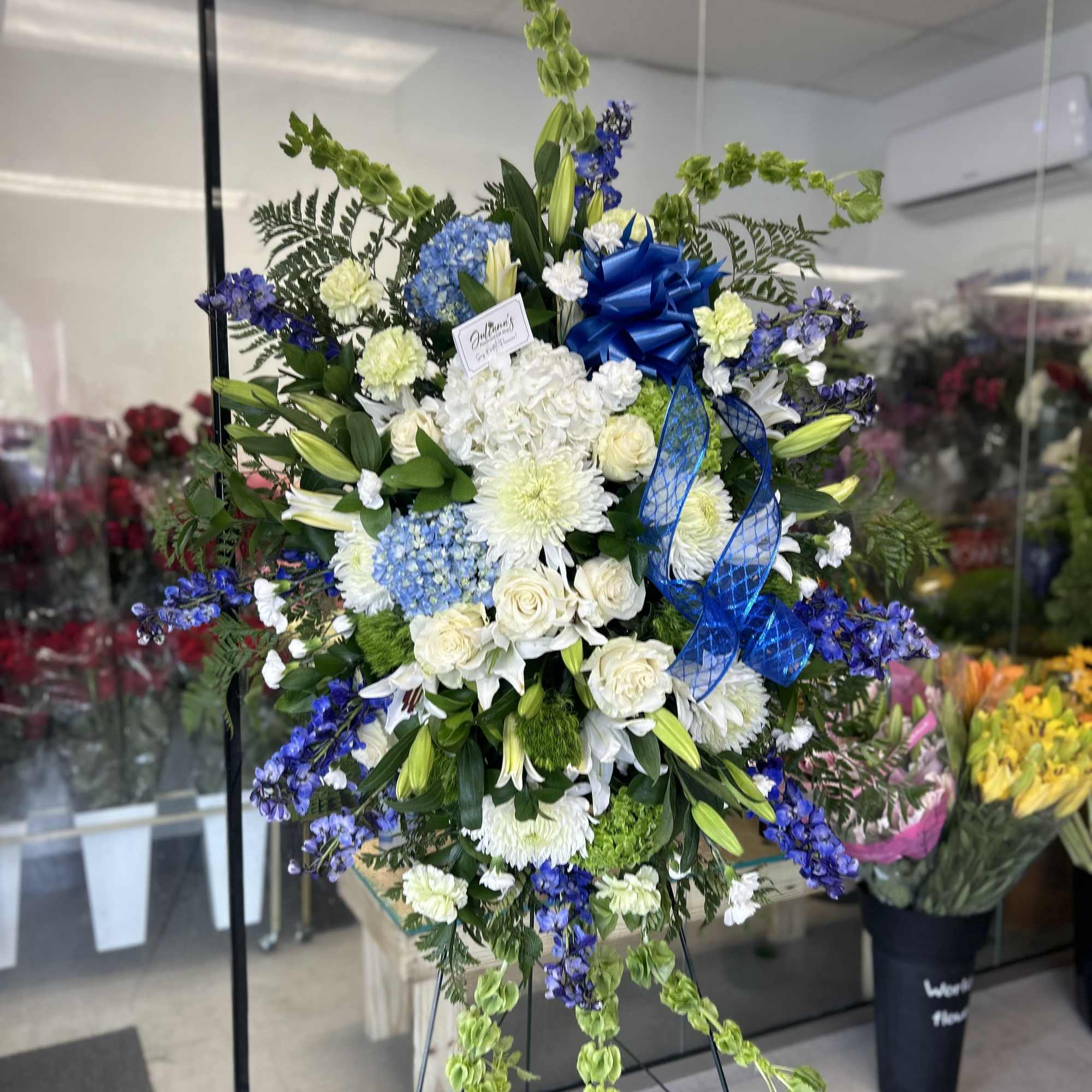 Blue and white elegant funeral arrangements on a standing spray honoring the