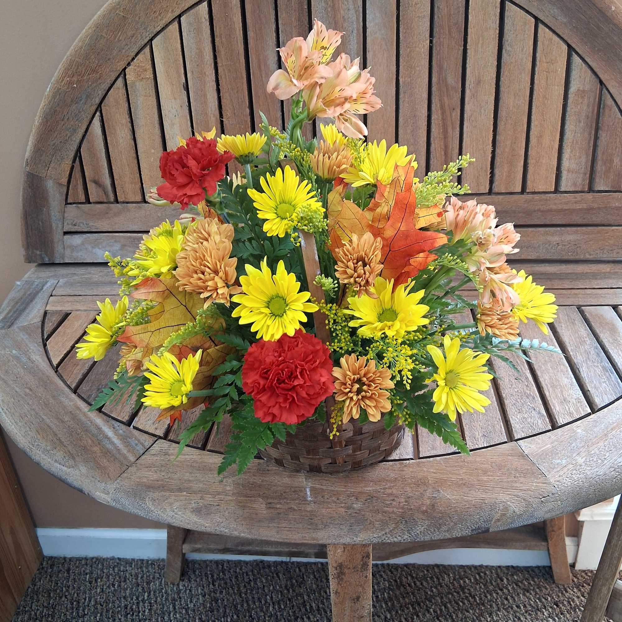 Mixed fall colored flowers in a basket.